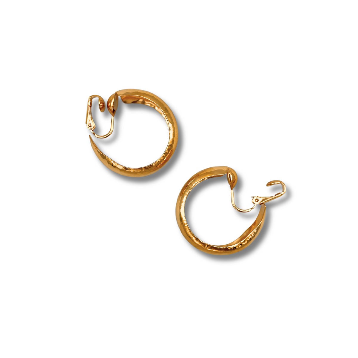 Les or Rush créole boucles d'oreilles par JAREDJAMIN Bijoux en Ligne présentent a hammered texture, 1 1/4" diameter, et hinged clip closures. Crafted in luxurious 18K or plate, they appear sur un fond blanc avec subtle shadows beneath them.