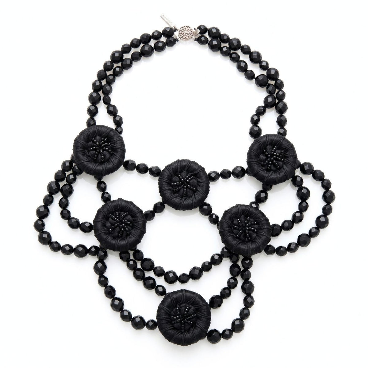 High-resolution, sharp e-commerce flat lay photography shot directly from above using a Canon EOS 5D Mark IV with a macro lens, featuring the JAREDJAMIN Good Mourning Victoria Necklace on a crisp white background to highlight the black faceted glass beads and satin-wrapped vintage buttons.