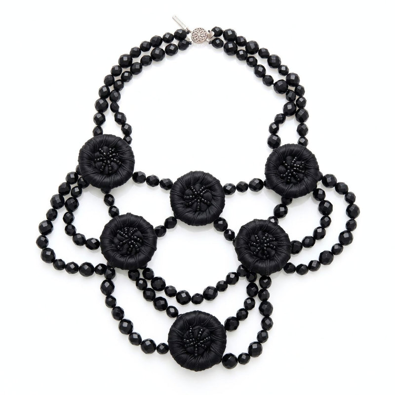 High-resolution, sharp e-commerce flat lay photography shot directly from above using a Canon EOS 5D Mark IV with a macro lens, featuring the JAREDJAMIN Good Mourning Victoria Necklace on a crisp white background to highlight the black faceted glass beads and satin-wrapped vintage buttons.