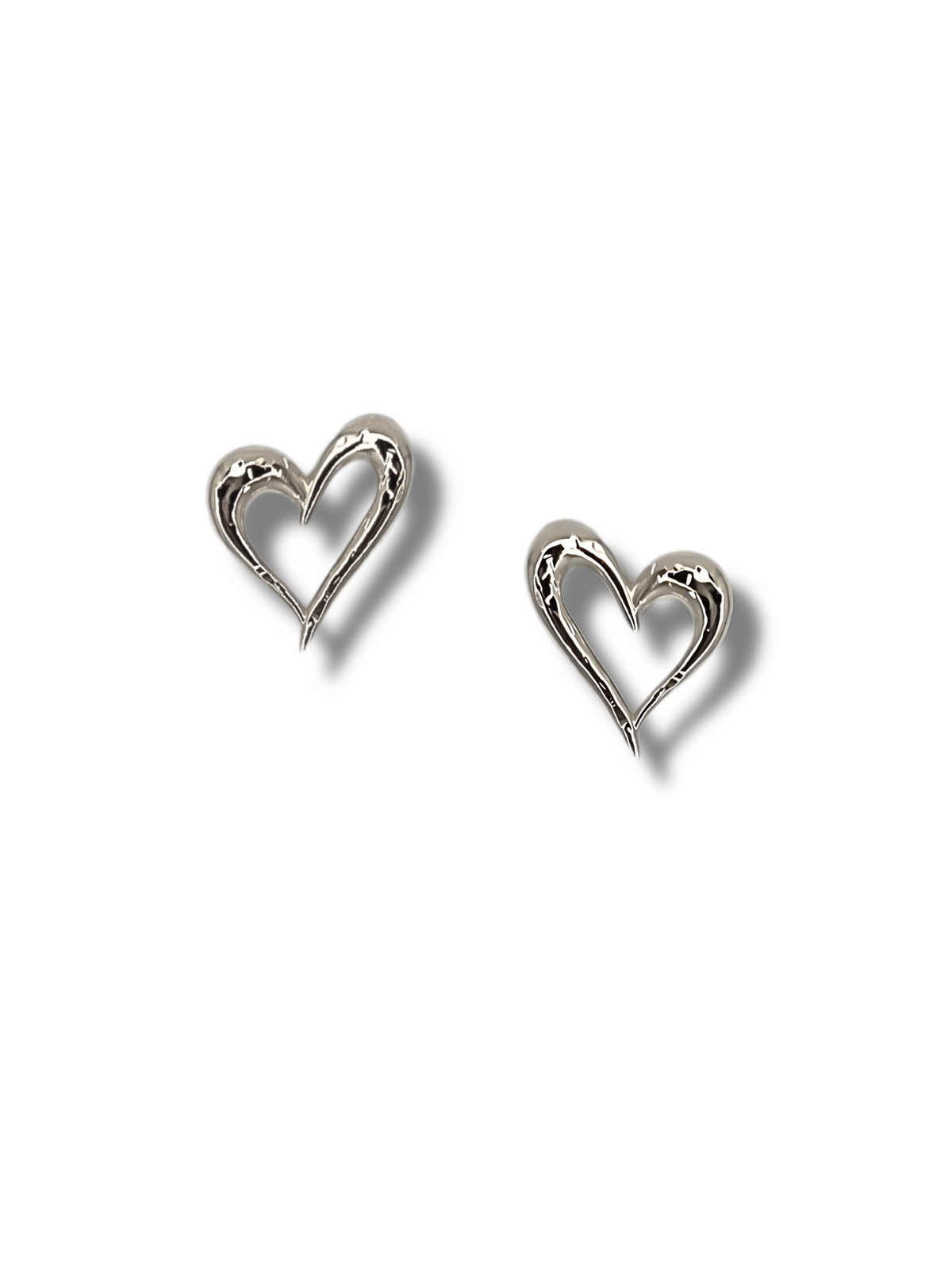 Against a plain white background, JAREDJAMIN Jewelry Online&#39;s &quot;Heartfelt Earrings&quot; shine with their polished, reflective silver surface. Their open heart-shaped design highlights elegant curves and a smooth finish—an unforgettable gift symbolizing timeless romance.