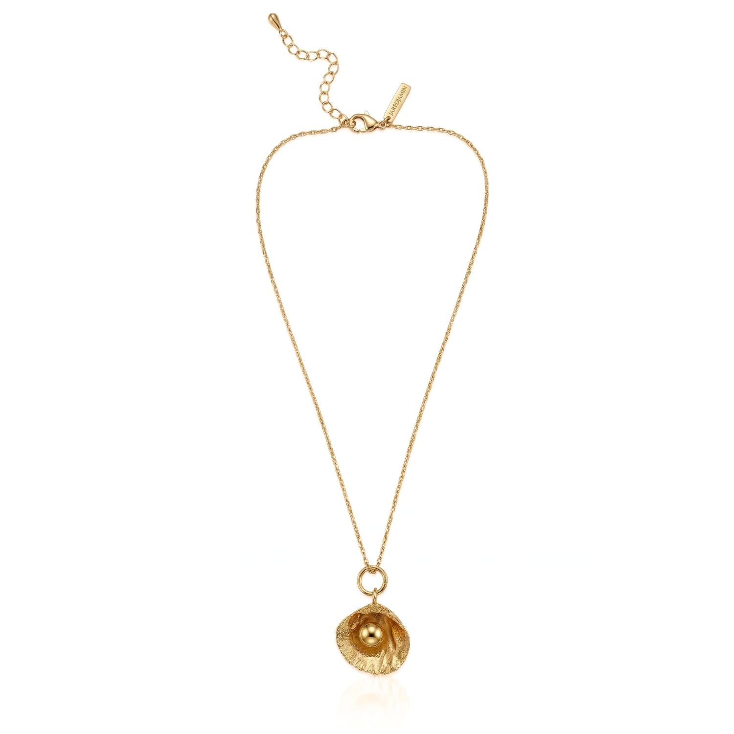 The Hidden Glimmer Pendant Necklace by JAREDJAMIN Jewelry Online features 18k gold plating, an adjustable chain, a shell-shaped pendant with a shiny gold pearl, extra clasp links, and a branded tag, shown on a white background.