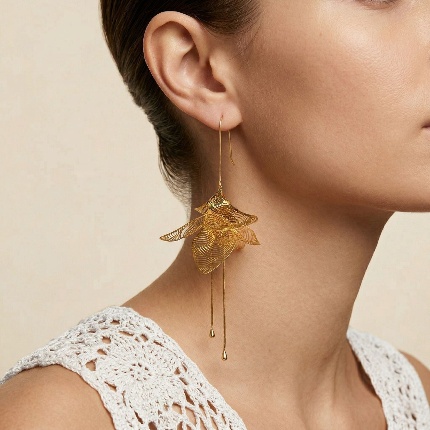 High-resolution studio product shot of the pair of gold JAREDJAMIN Leilani Statement Earrings against a clean white backdrop, detailing their three-dimensional 18k gold-plated brass petal clusters, laser-cut filigree, and long kinetic stamens.