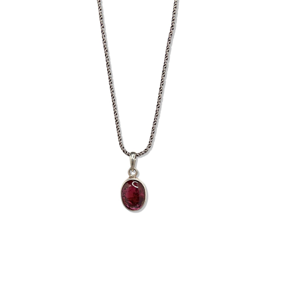The Gage Garnet Necklace by JAREDJAMIN Jewelry Online showcases a fine sterling silver chain and an oval garnet charm in a simple bezel setting, highlighted against a white background with a hook clasp and rich red gemstone.
