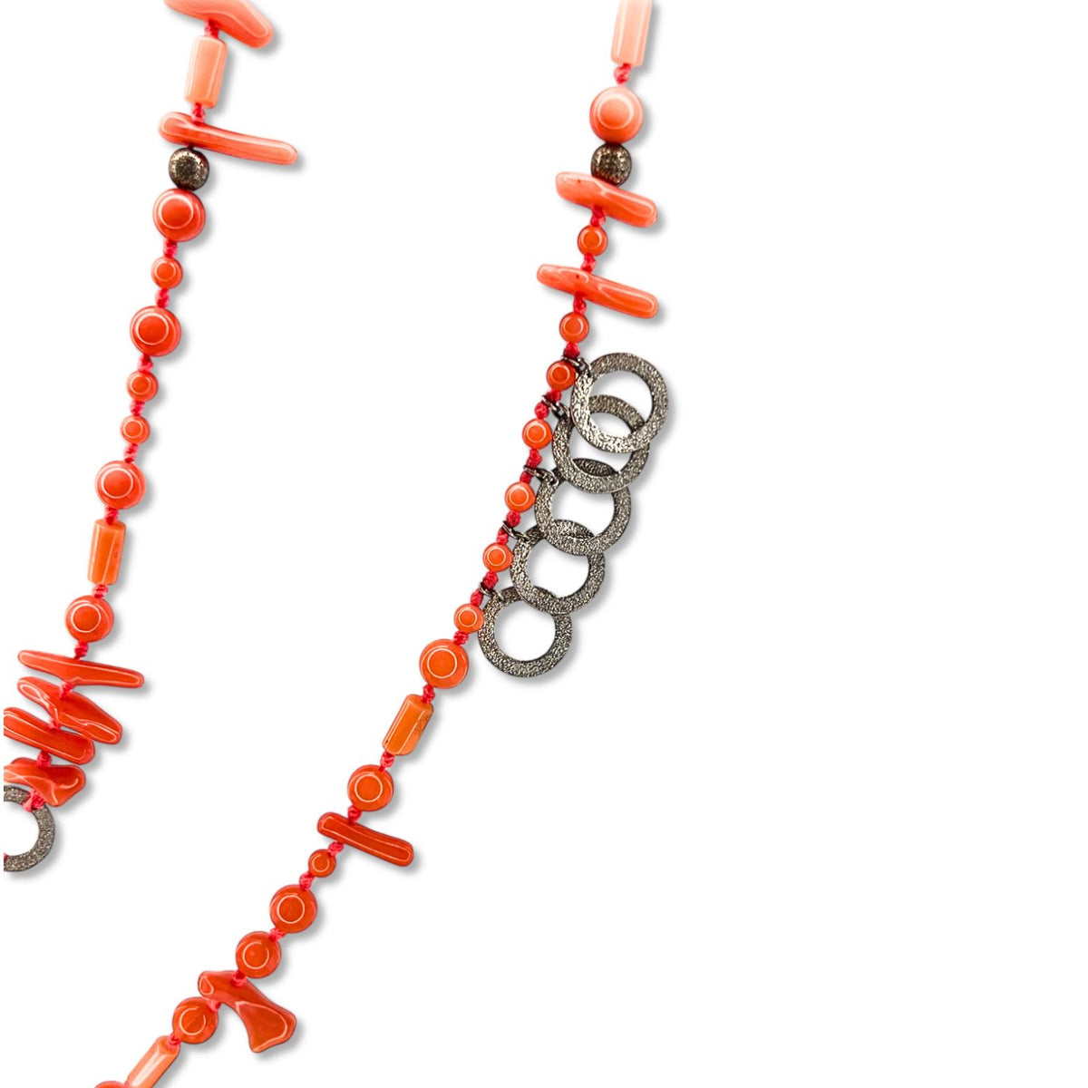 The Aural Pink Coral Necklace by JAREDJAMIN Jewelry Online features irregular bamboo coral beads, round red accents, textured silver rings, and brownish beads, shown on a white background with part of the necklace out of view.