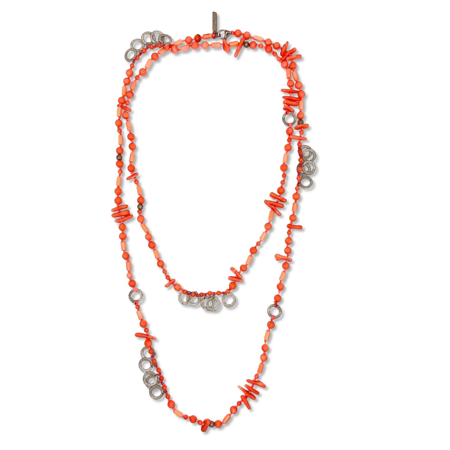 The Aural Pink Coral Necklace by JAREDJAMIN Jewelry Online features small round and stick-shaped bamboo coral beads with sterling silver accents, arranged in loops for a vibrant orange and metallic look on a white background.