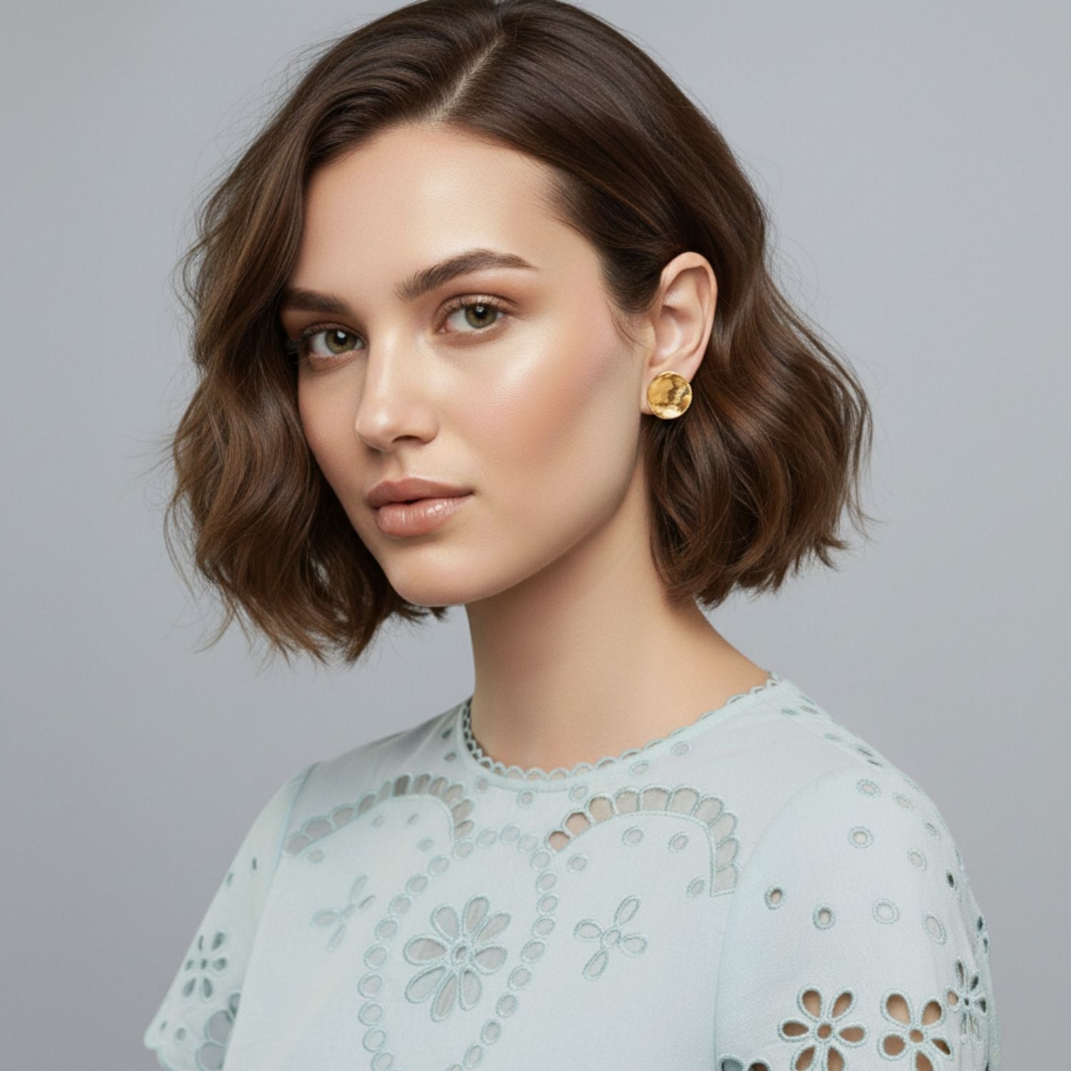 The Buttercup Textured Stud Post Earrings by JAREDJAMIN Jewelry Online feature a round, concave shape in 18K gold-plated brass with a hammered texture that highlights their shiny, reflective finish against a white background.
