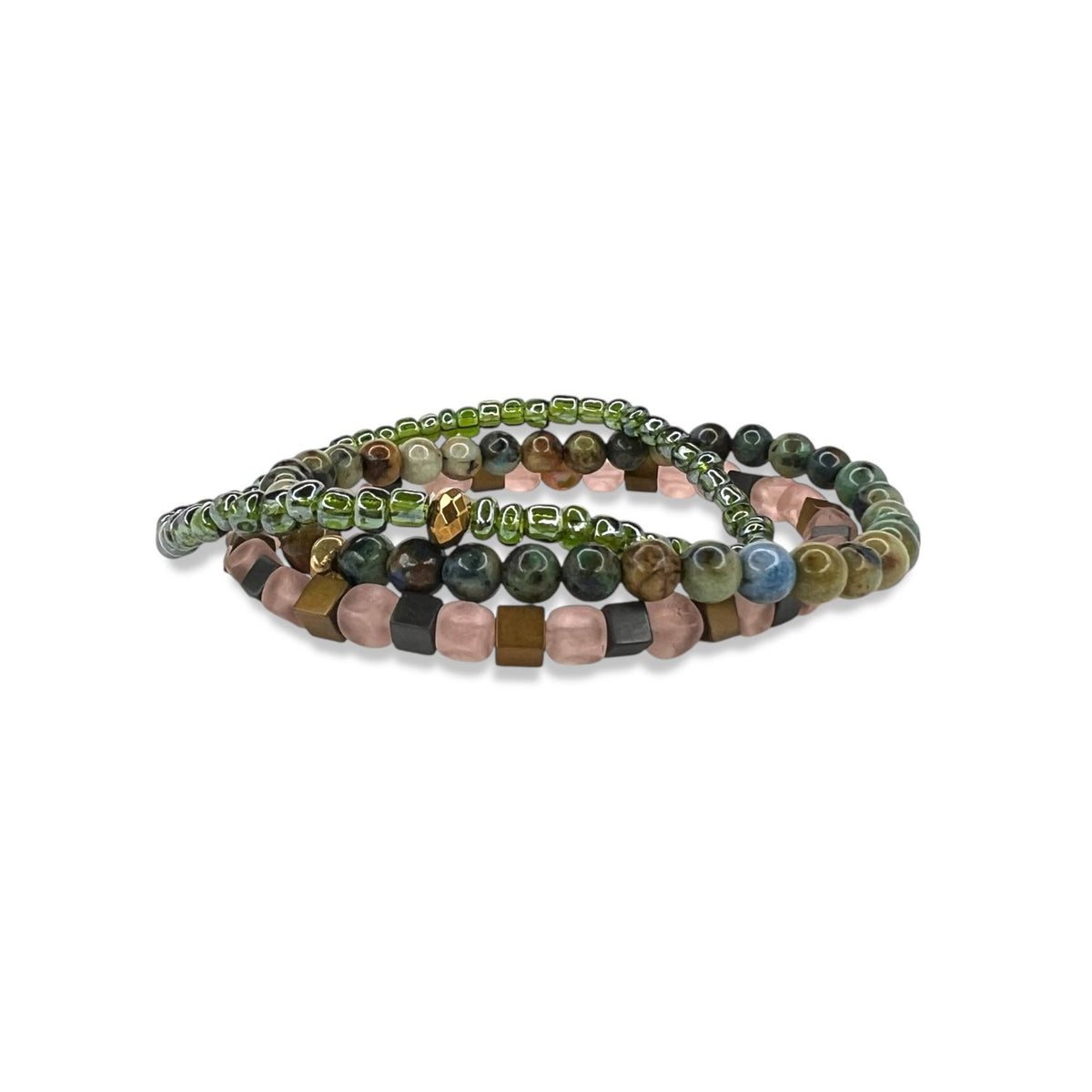 Les Byzantine Rocks bracelet Set par JAREDJAMIN Bijoux en Ligne features three coiled bracelets: one avec green glass beads, one avec earthy round brown, green, et blue beads, et another avec pink et brown cube beads sur un fond blanc.
