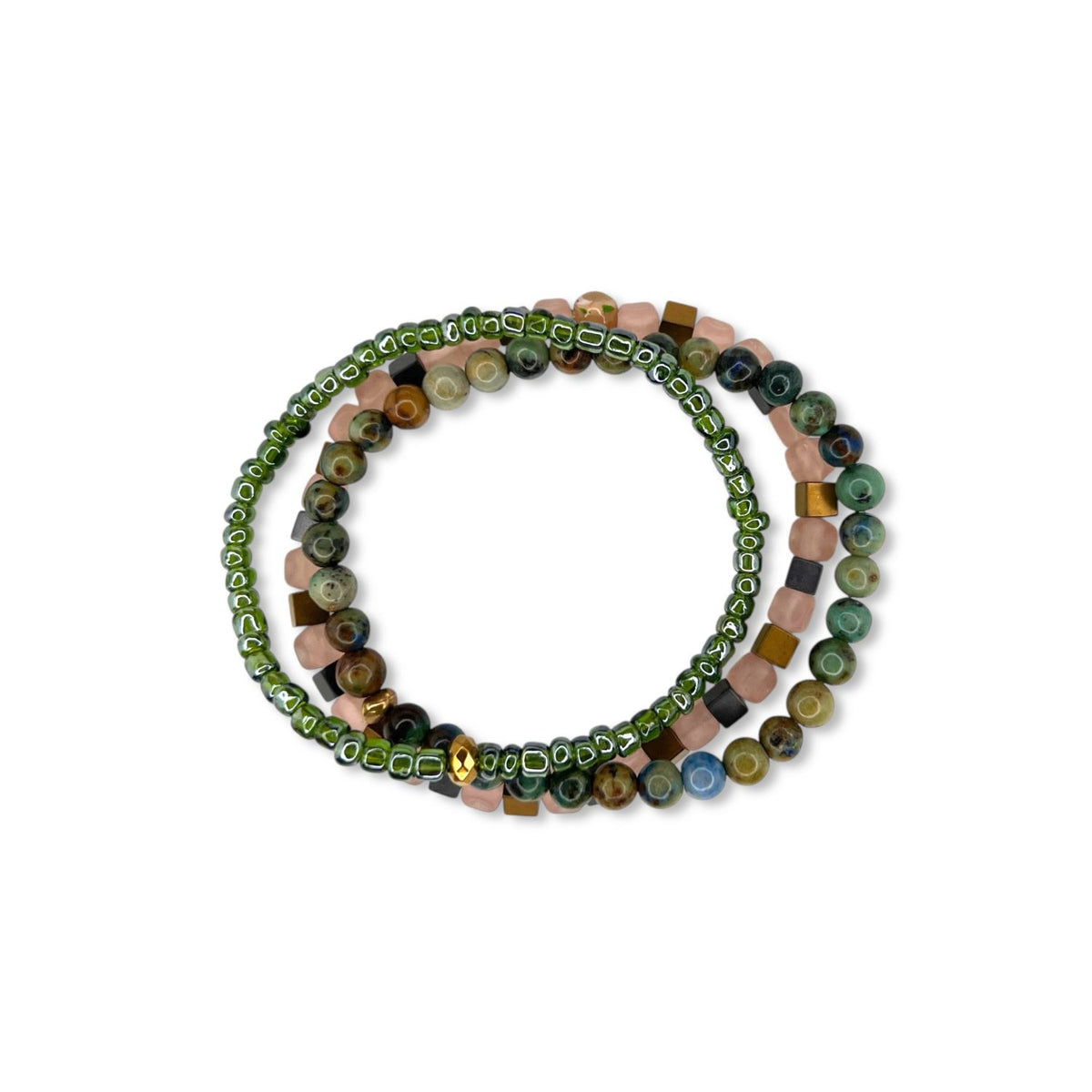 Les Byzantine Rocks bracelet Set par JAREDJAMIN Bijoux en Ligne is displayed coiled sur un fond blanc. One bracelet has small green glass beads et a or accent; the other features jasper beads in earthy green, brown, blue, et pink.
