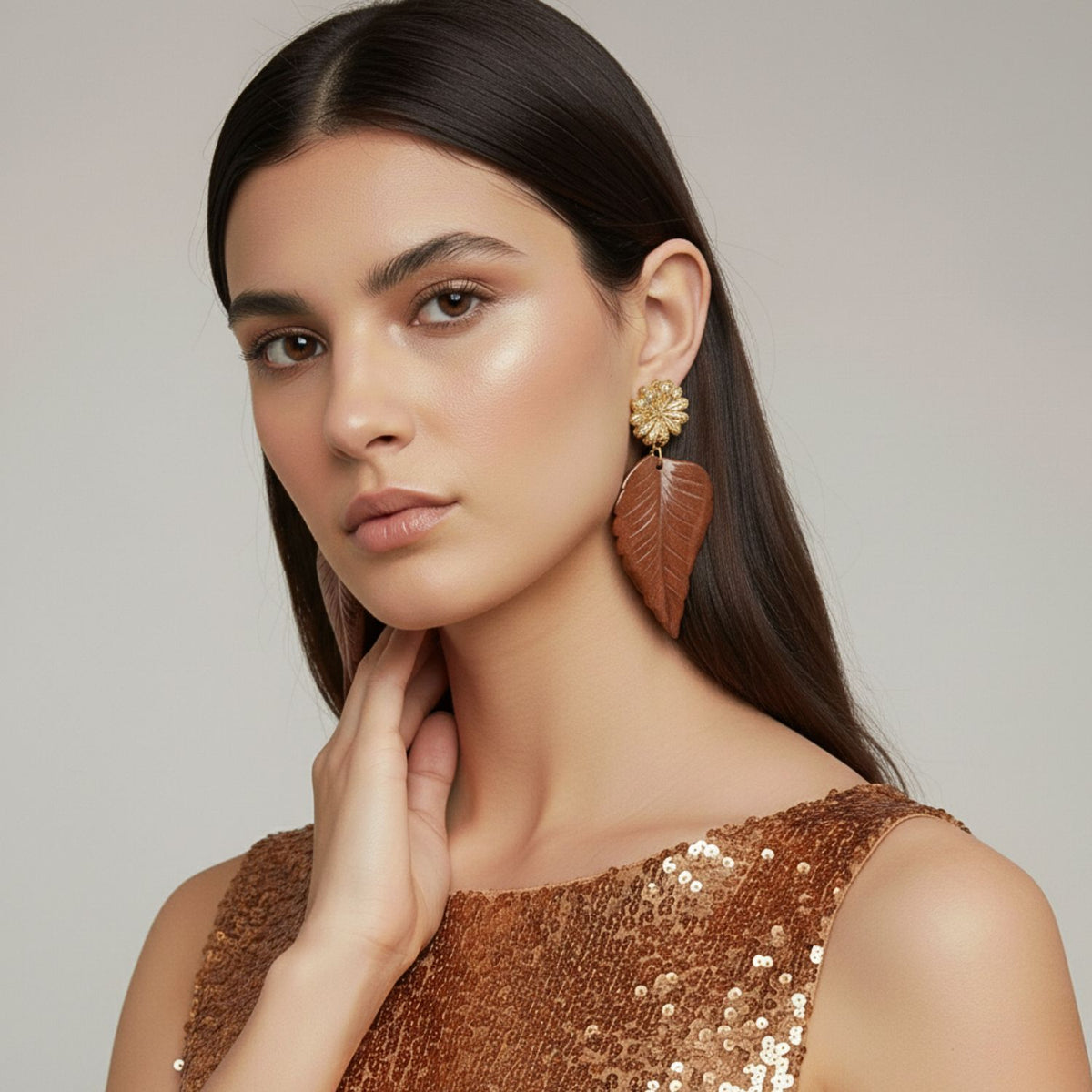 Chrysanthemum Clip on イヤリング in Sandstone JAREDJAMIN製—a brushed, artisanal piece crafted in small batches ウエストハリウッド, embodying sustainable ラグジュアリーとsignature finishes—are worn by a woman の中の sequined bronze top.