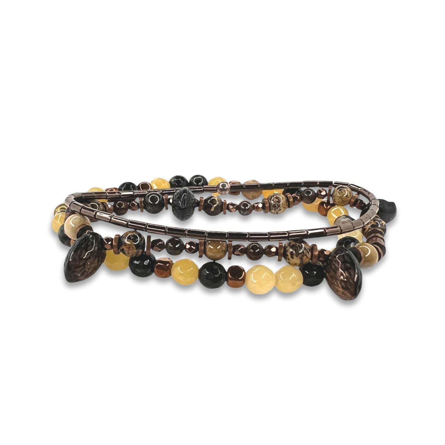 The Coconino Bracelet Set by JAREDJAMIN Jewelry Online features coiled beads in earthy brown, amber, yellow, and black tones. It combines round, faceted, and oval beads with yellow quartz for a striking look against a white background.