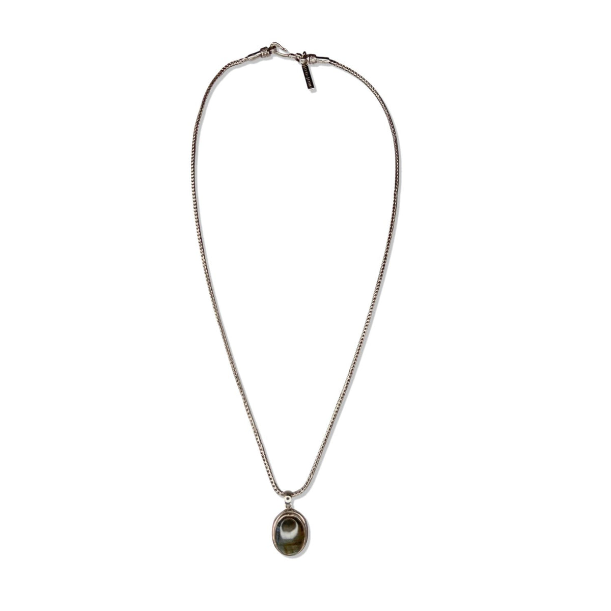 The Confidence Boost Necklace by JAREDJAMIN Jewelry Online is a thin sterling silver chain with a small oval green stone pendant, bezel-set in silver, displayed flat on a white background with clasp and tag at the top.
