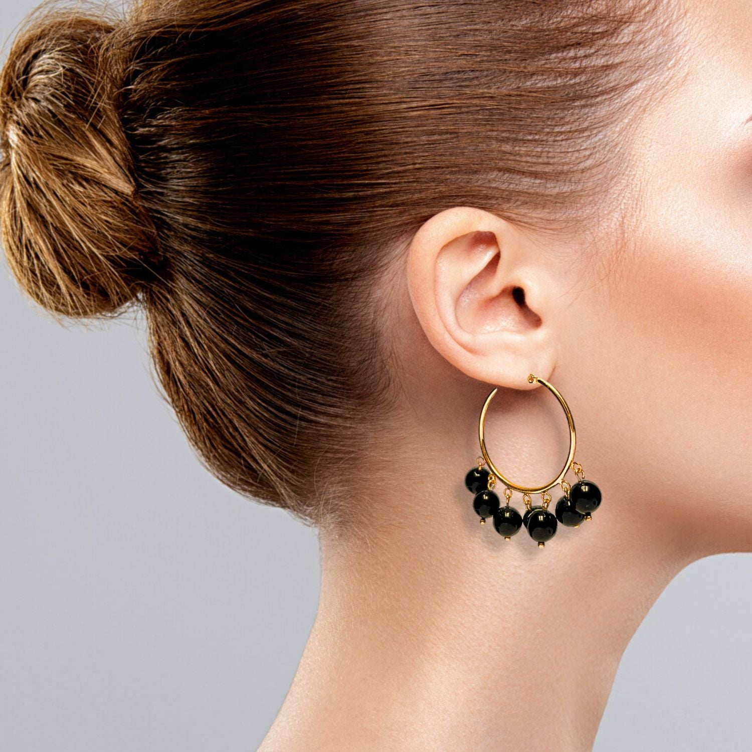 The Daniela Hoop Onyx Earrings by JAREDJAMIN Jewelry Online feature 18K gold hoops with six evenly spaced round onyx beads on each, attached by small gold links and secured with a latch closure, shown against a white background.