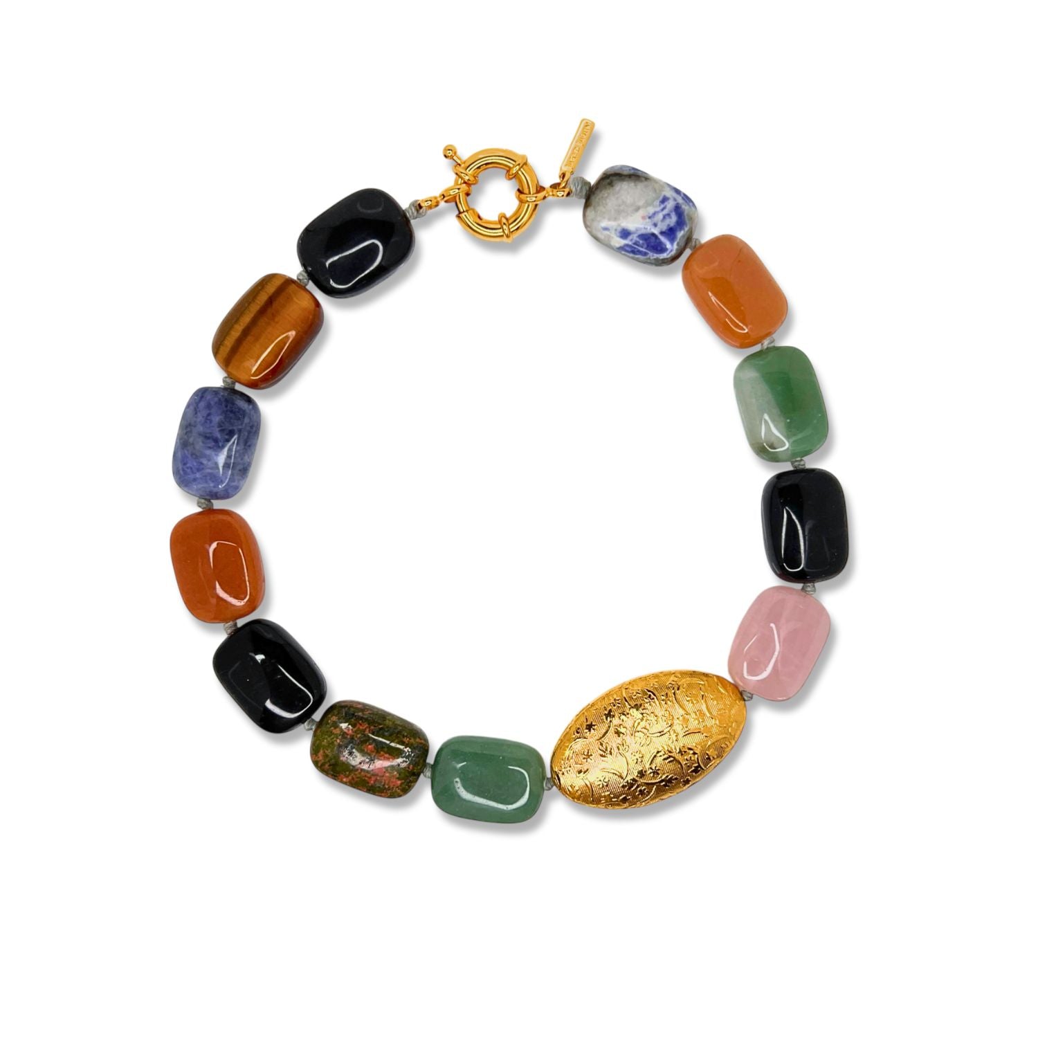 The Earthen Elegance Gemstone Necklace by JAREDJAMIN Jewelry Online displays multicolored rectangular aventurine and rose quartz beads with a large engraved gold oval bead and gold toggle clasp, arranged in a circle on a white background.