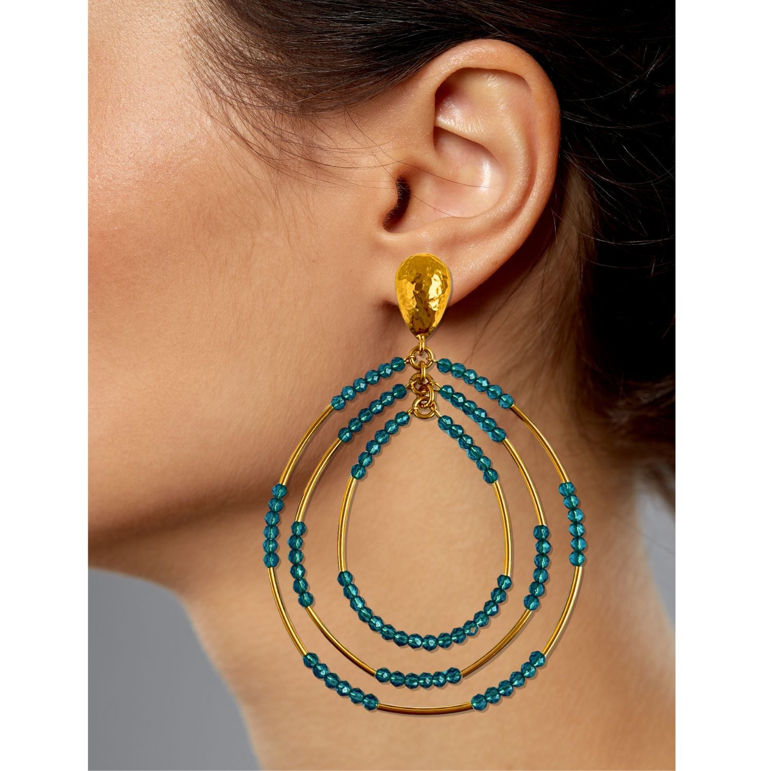 The Easy Breezy Turquoise Post Earrings by JAREDJAMIN Jewelry Online feature gold-plated teardrop studs with three concentric gold loops partially adorned with turquoise crystals for a bold, layered look.