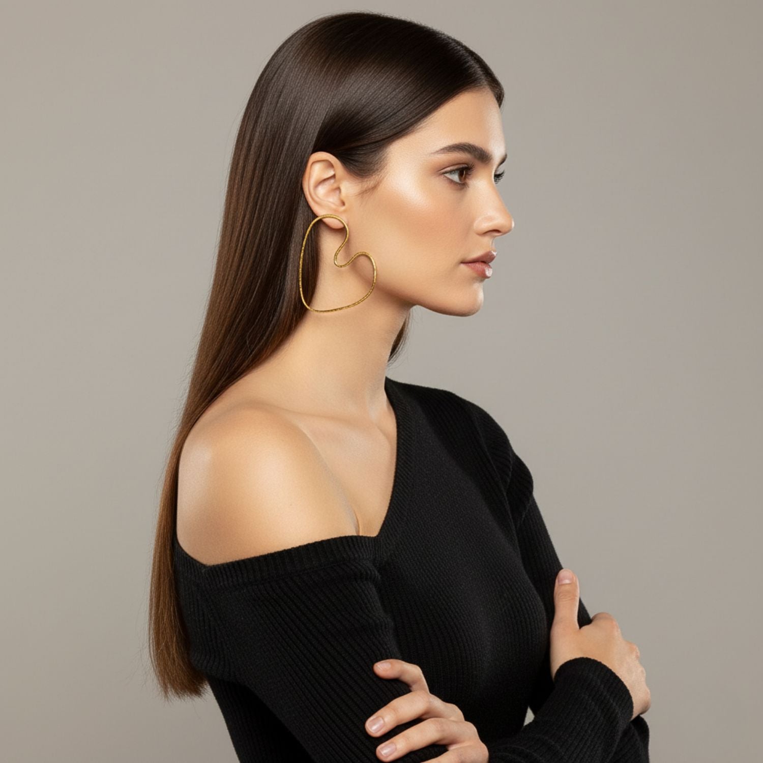 Gold Large Fluttering Heart Earrings by JAREDJAMIN Jewelry Online are shown on a white background. The 18K gold-plated, handmade wire hearts feature delicate, polished outlines with a unique asymmetrical shape.