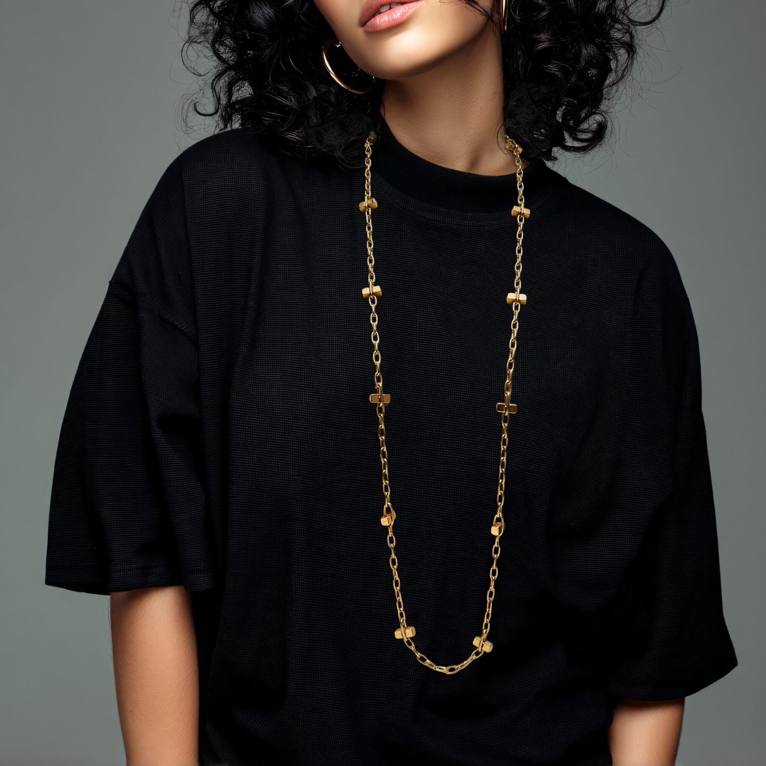 The JAREDJAMIN Jewelry Online Gold Blockbuster Lite Long Necklace is an 18K gold plated link chain adorned with evenly spaced small cross charms, offering a simple and elegant look against a white background.