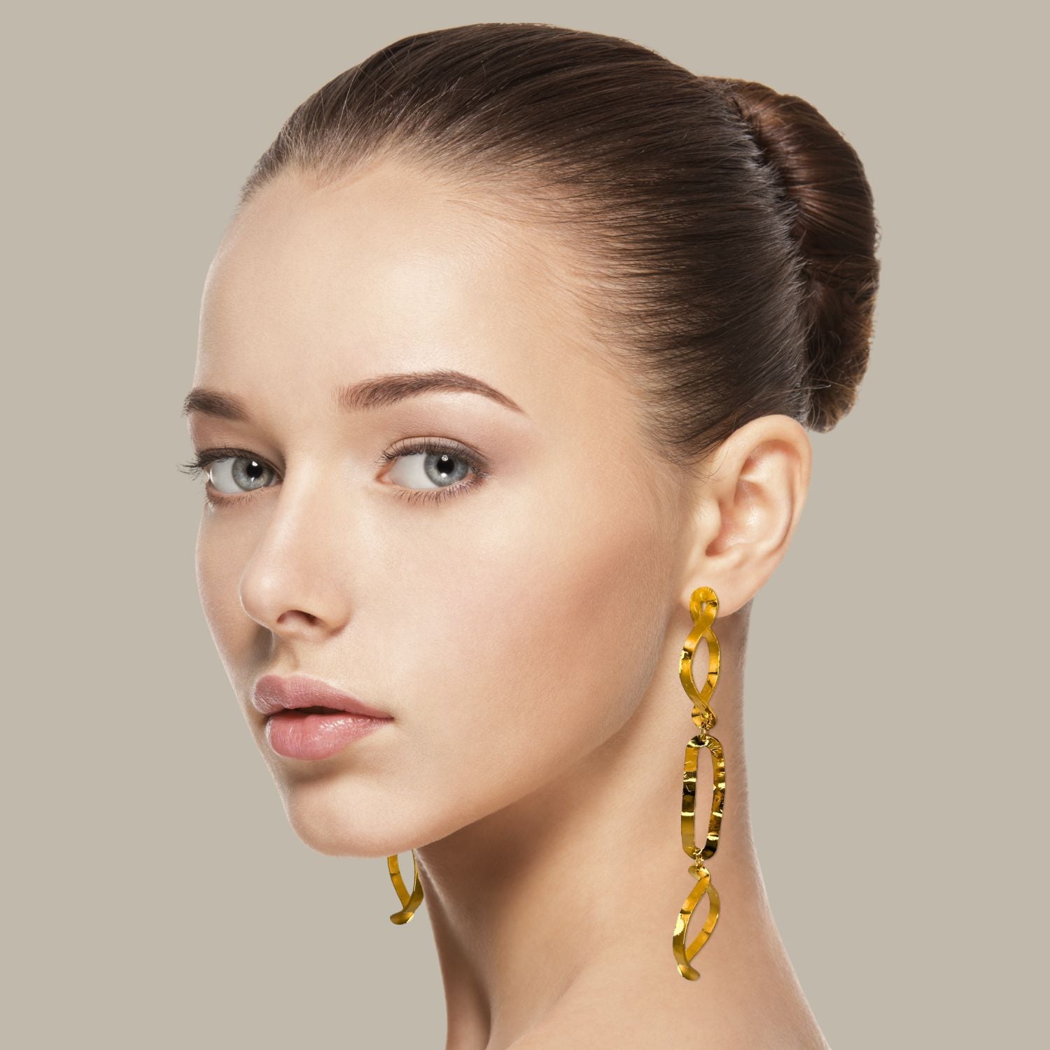 The Gold Darla Dangle Earrings by JAREDJAMIN Jewelry Online feature mismatched, 18K gold-plated ovals with unique textures and shapes, dangling from flat hooks—a modern Los Angeles Design Studio creation.