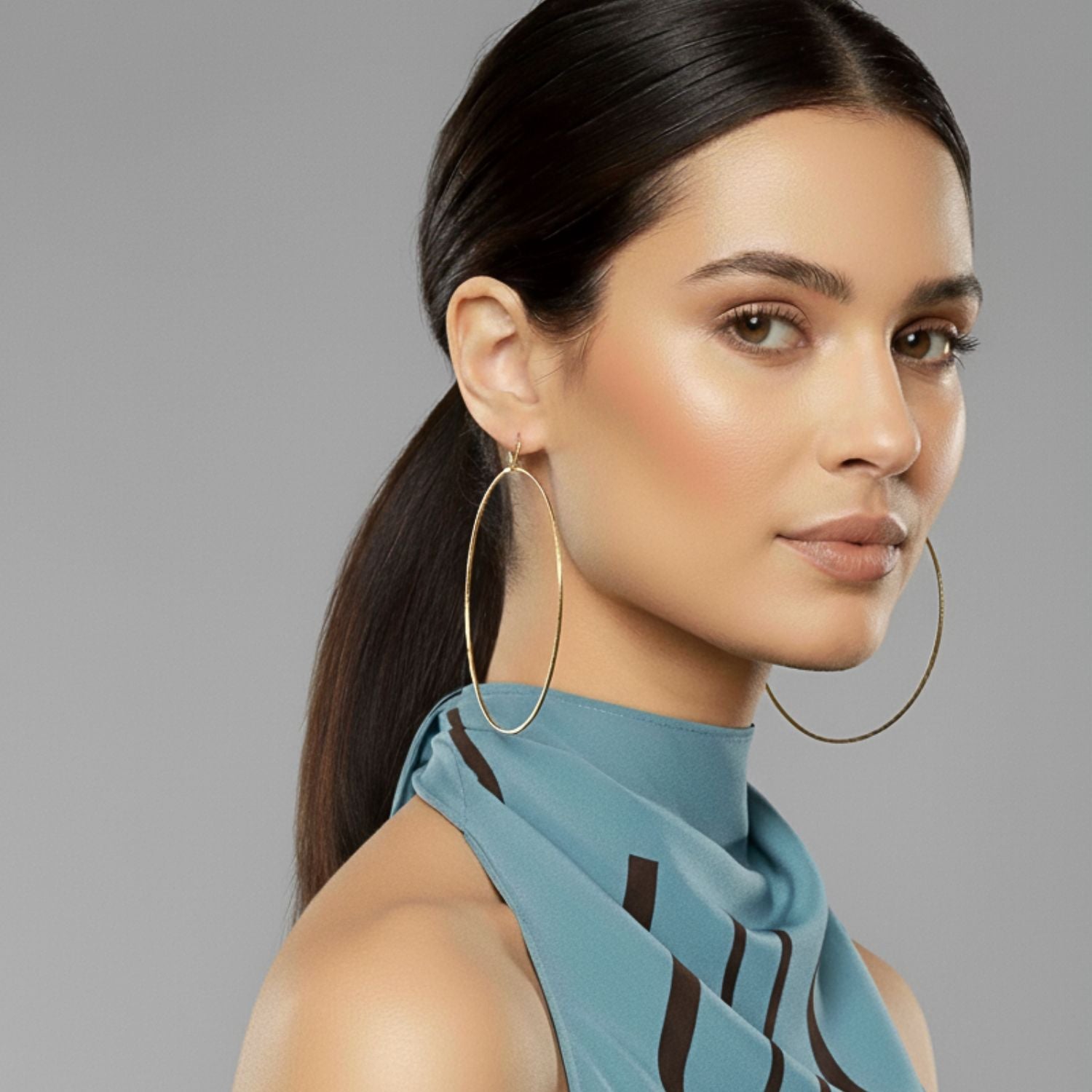 The Gold Halo Textured Hoop Earrings by JAREDJAMIN Jewelry Online are large, thin hoops with a minimalist design and slight texture, featuring small circular clasps. Displayed against a plain white background, their shape is subtly irregular and unadorned.