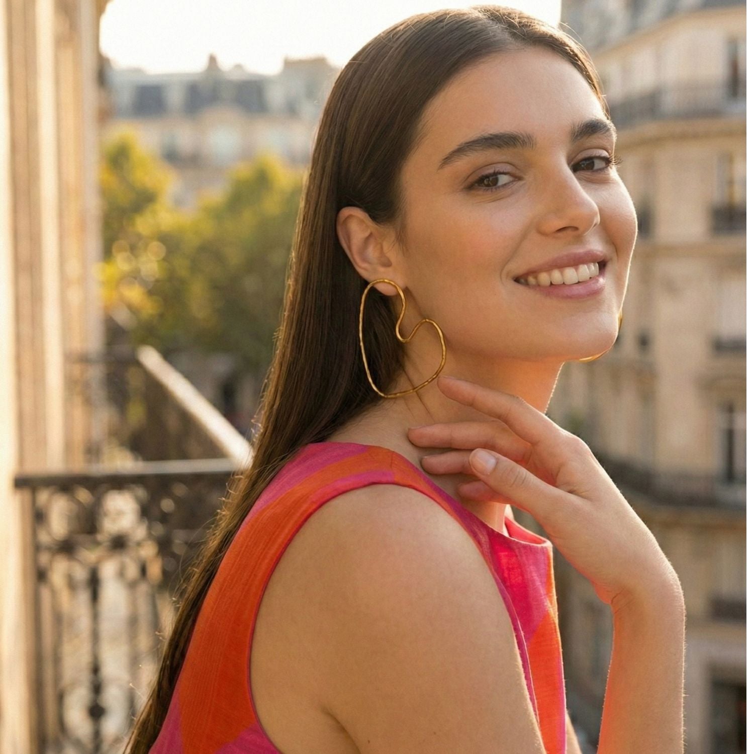 Gold Large Fluttering Heart Earrings by JAREDJAMIN Jewelry Online are shown on a white background. The 18K gold-plated, handmade wire hearts feature delicate, polished outlines with a unique asymmetrical shape.