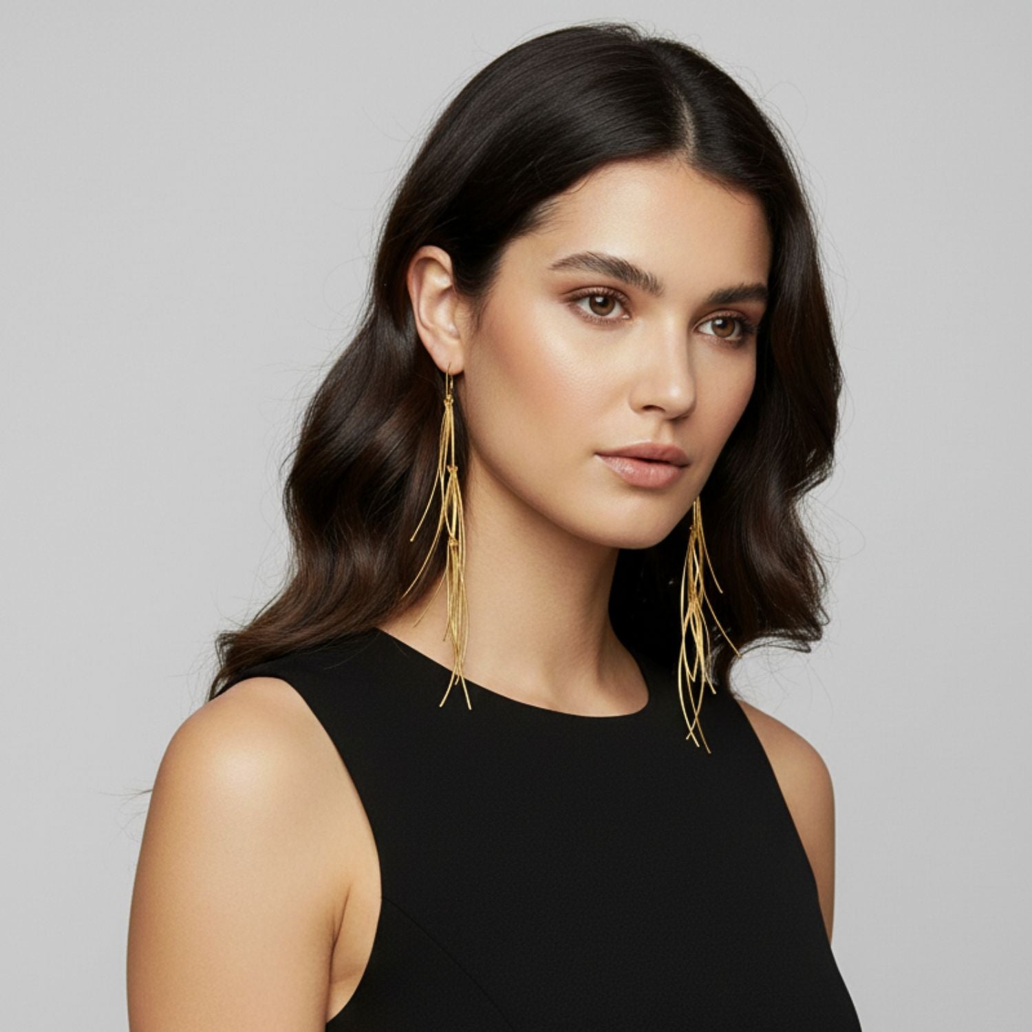 The Gold Long Tinsel Earrings by JAREDJAMIN Jewelry Online are asymmetrical 18K gold plated dangle earrings with thin, curved strands. The left is shorter and simpler, the right is longer and layered; both have secure lever back closures.