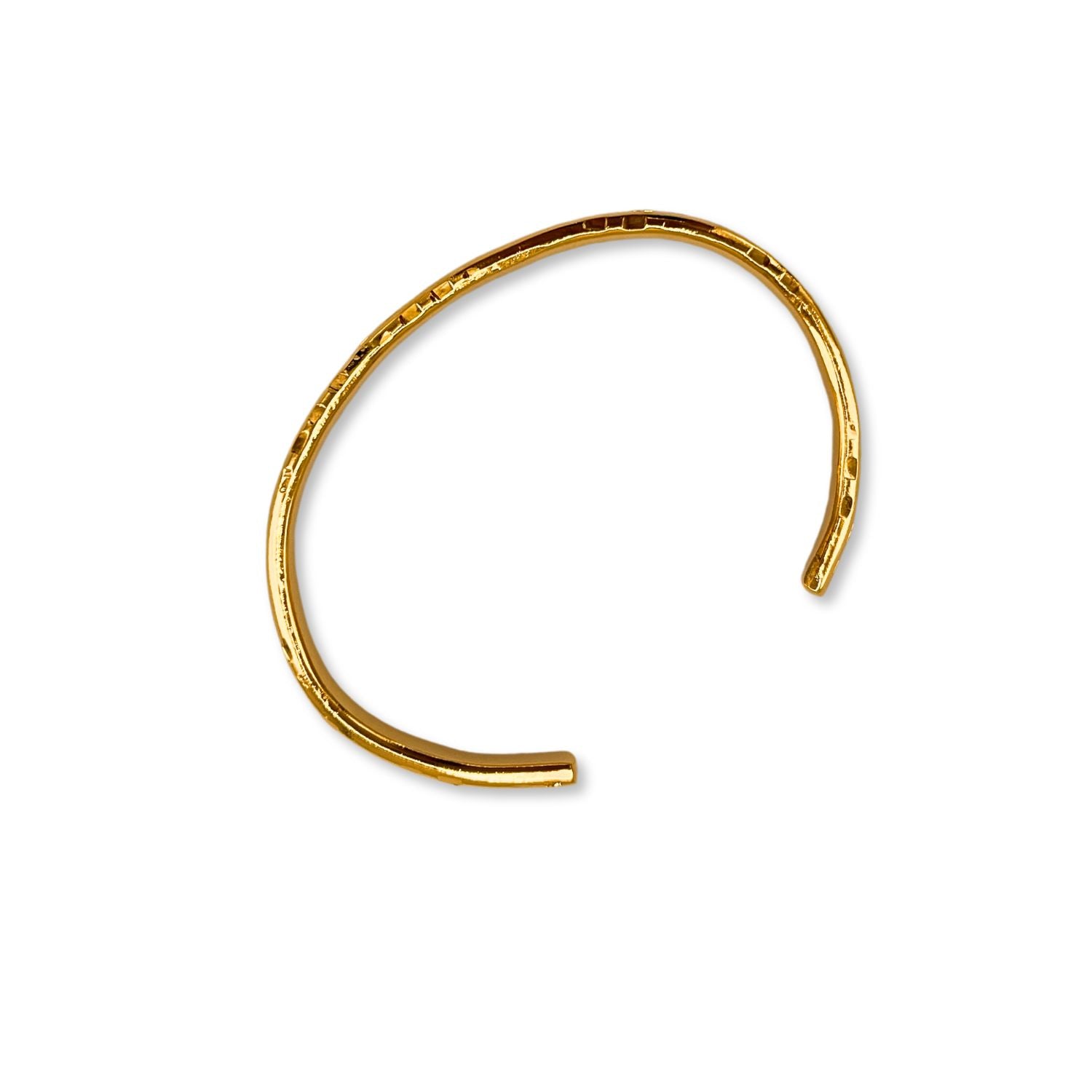 A close-up of the Gold Parker Textured Cuff by JAREDJAMIN Jewelry Online, an open-ended 18K gold plated bracelet with a hand-hammered finish, gleaming with a polished, minimalist elegance against a white background.