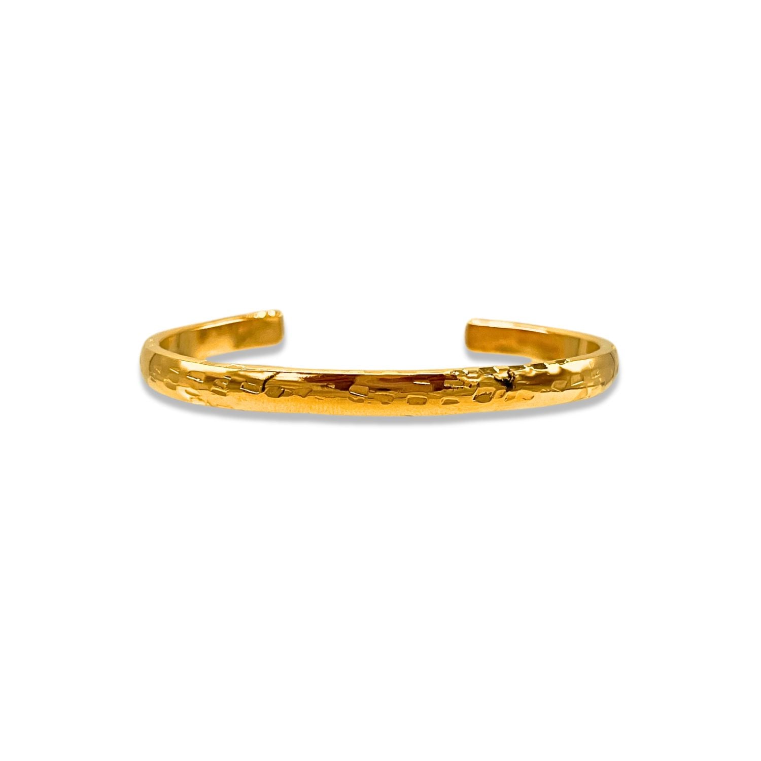A close-up of the Gold Parker Textured Cuff by JAREDJAMIN Jewelry Online, an open-ended 18K gold plated bracelet with a hand-hammered finish, gleaming with a polished, minimalist elegance against a white background.