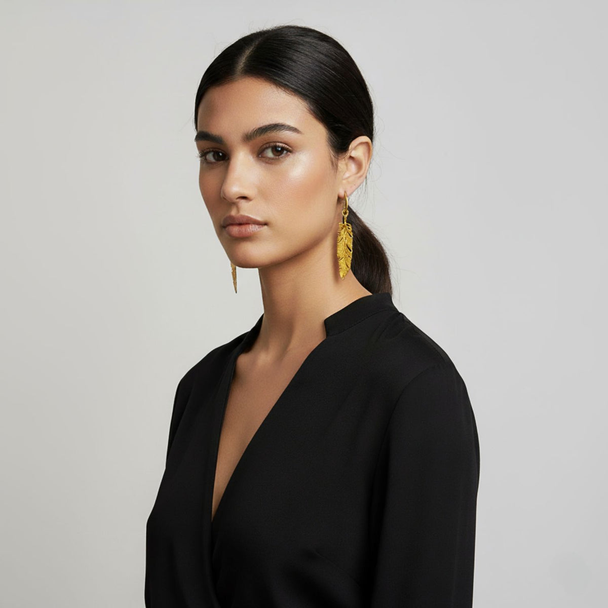 mannequin portant the 4-inch Jared Jamin or Plume Dangle boucles d'oreilles, highlighting the élégant vertical feather pendante et high-shine 18K plaqué or finish.