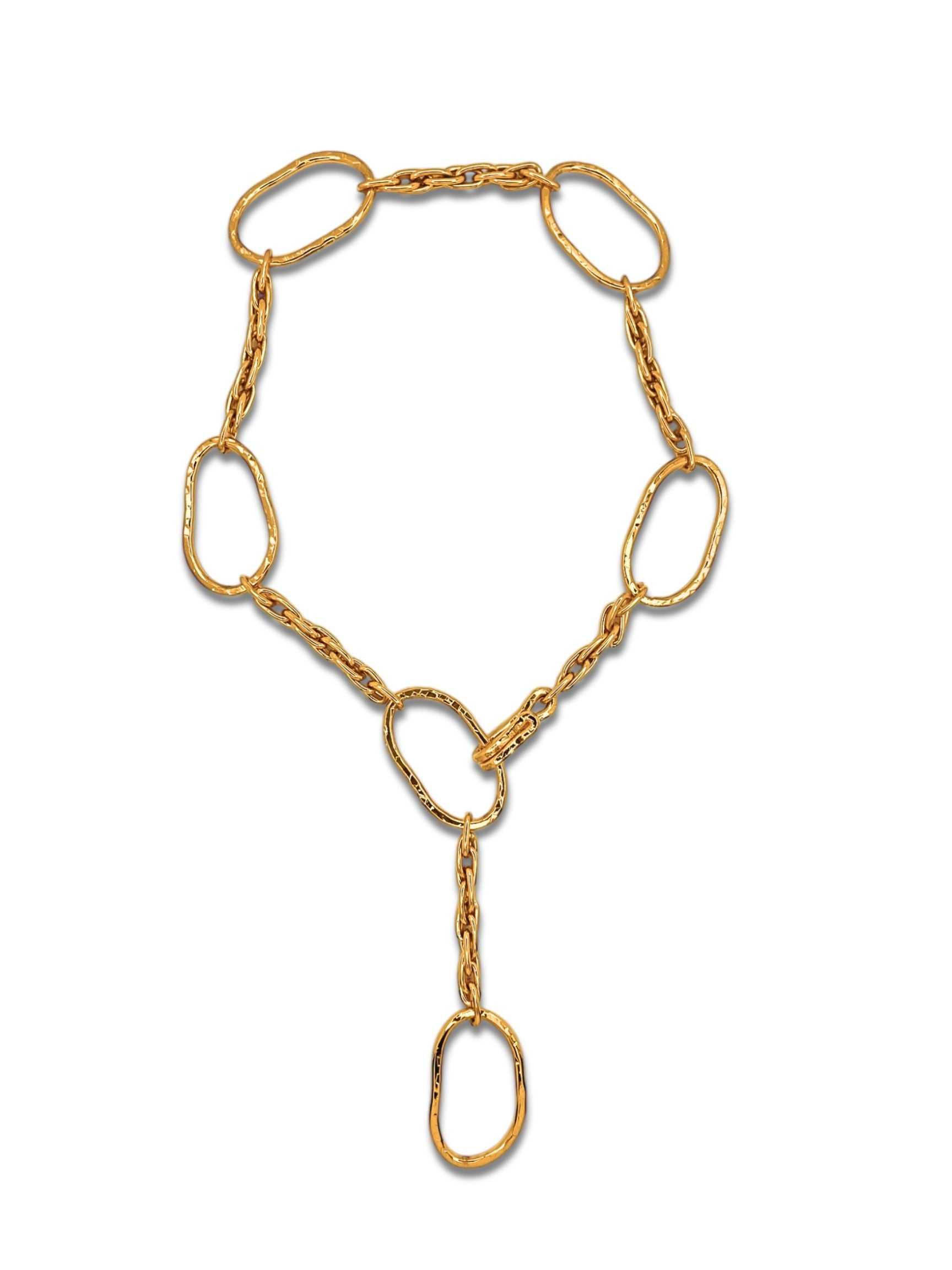 The Gold Shackle and Rope Link Necklace by JAREDJAMIN Jewelry Online features large, irregular oval-shaped links connected by smaller double chain links. An extended 18K gold plated chain dangles, creating a drop effect with a shiny finish and modern, elegant design.