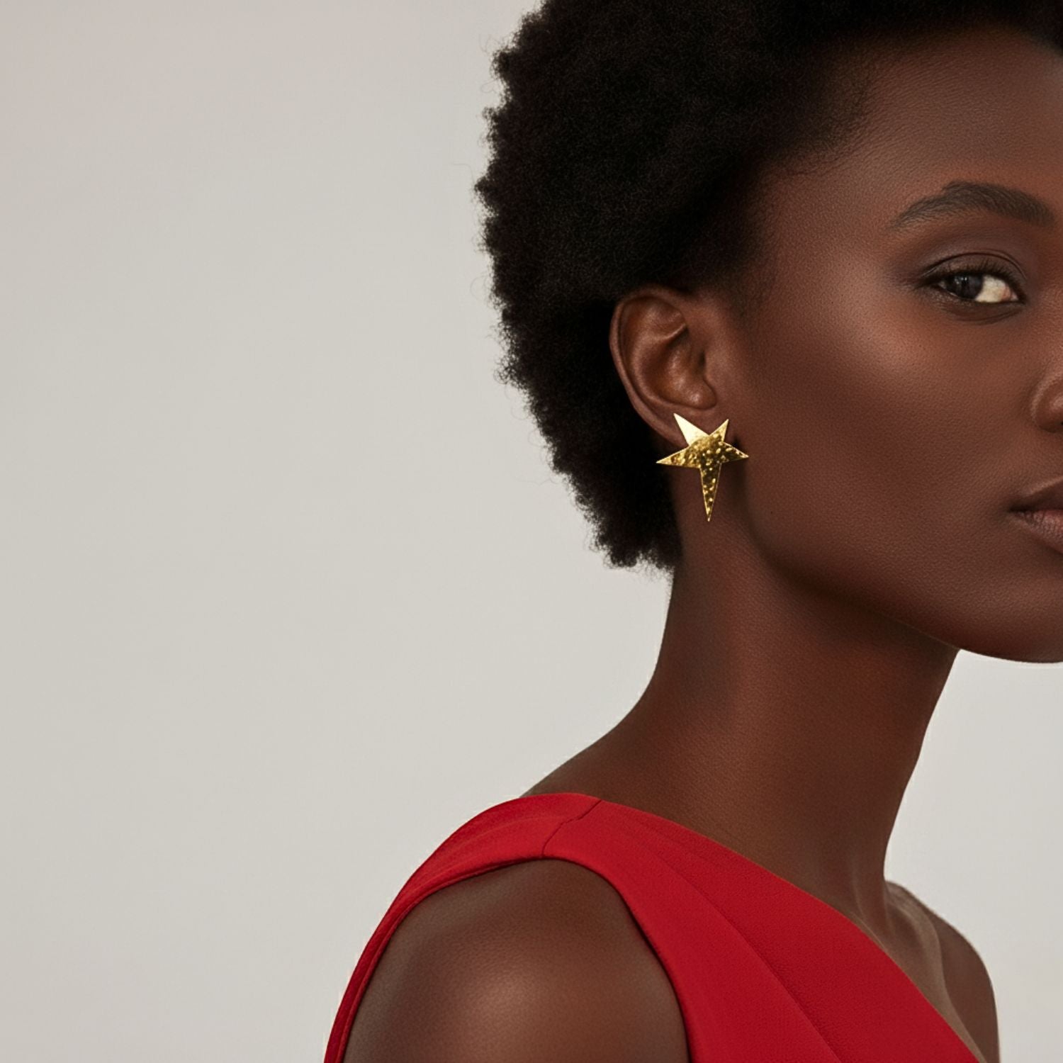 The Gold Shooting Star Clip On Earrings by JAREDJAMIN Jewelry Online feature a hammered, 18K gold-plated finish with five pointed tips—one elongated for a dynamic look. Their textured, reflective surface and irregular dimples add modern flair.