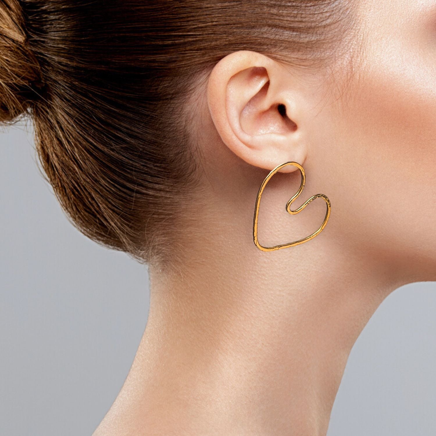 The Gold Small Fluttering Heart Earrings by JAREDJAMIN Jewelry Online feature thin, 18K gold, abstract heart shapes with irregular, open-ended designs and smooth curves, shown on a plain white background.
