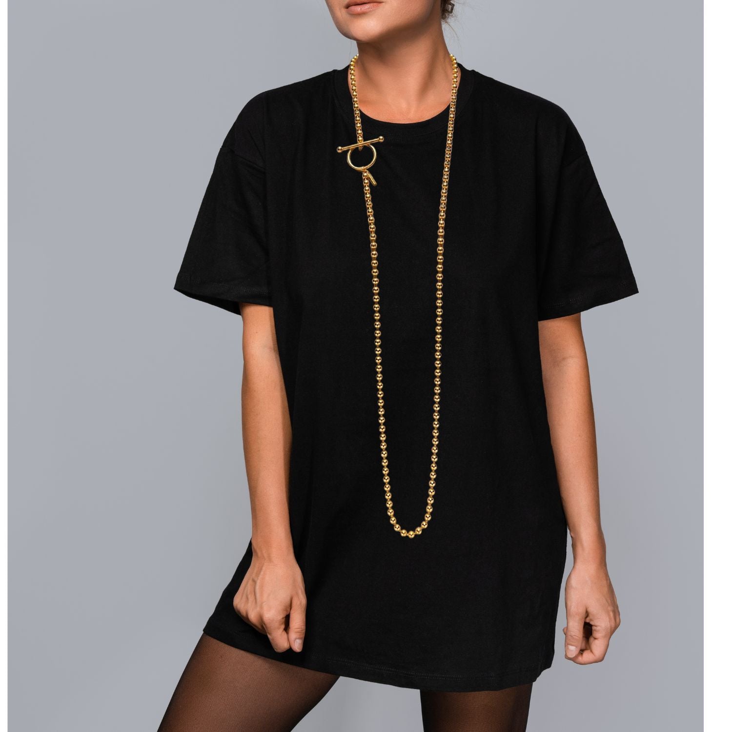 The Gold Constellation Orbita Necklace by JAREDJAMIN Jewelry Online features evenly sized gold beads and a circle-and-bar toggle clasp, arranged in a loose oval with a soft shadow on a white background.