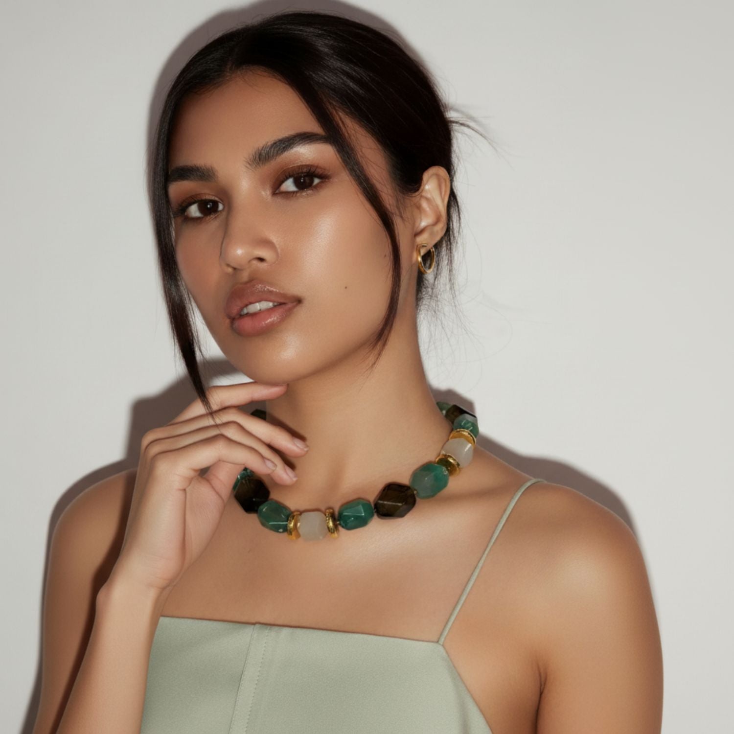 The Green Dream Necklace by JAREDJAMIN Jewelry Online features alternating faceted green agate, brown, and beige beads with gold spacers and an 18K plated clasp plus an adjustable chain for a polished geometric look.