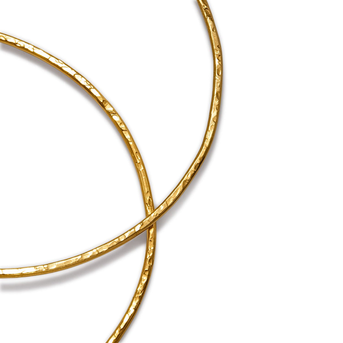 Two hammered 18K gold Gold Medium Hooptastic Clip On Hoop Earrings by JAREDJAMIN Jewelry Online, with a textured, reflective finish, intersect on a white background. Only part of each non-tarnish hoop is visible in the frame.