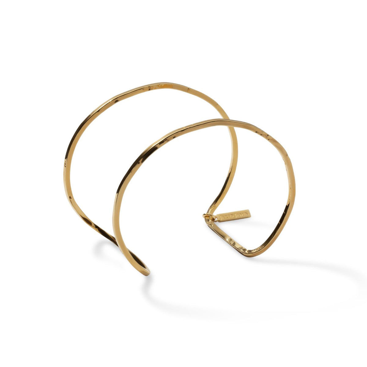 The Gold Halo Forge Textured Cuff by JAREDJAMIN Jewelry Online features two parallel, wavy 18K gold-plated brass bands and a small rectangular tag, shown on a plain white background to highlight its elegant, minimalist design.
