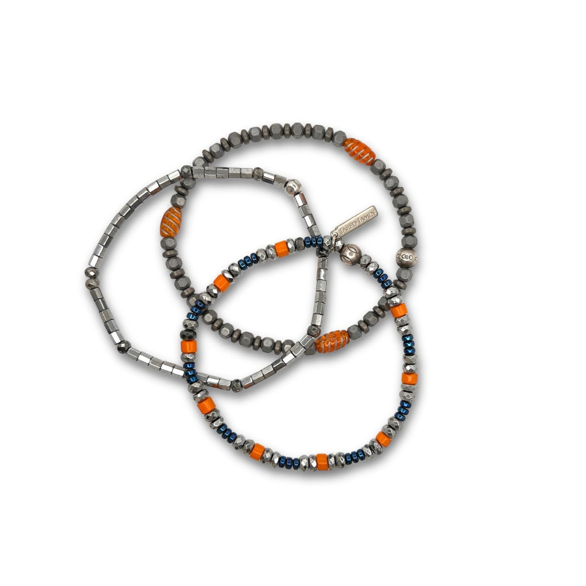 The Hot Rod Apache Bracelet Set by JAREDJAMIN Jewelry Online features three overlapping men’s casual beaded bracelets with silver hematite bars, gray and orange beads, and heishi beads in dark blue, orange, and white.