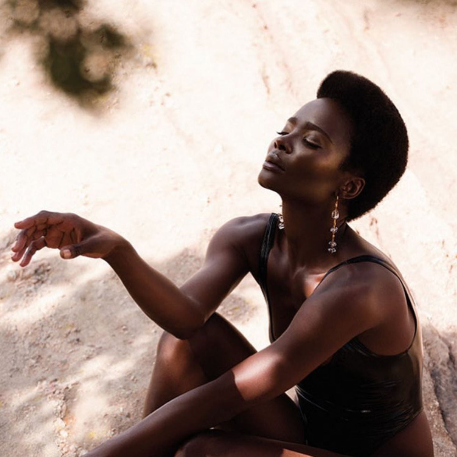 The Ice Dangle Gold Leverback Earrings by JAREDJAMIN Jewelry Online feature three clear, irregular crystal-like stones linked vertically by gold bars, blending metallic and translucent elegance in a modern statement design.