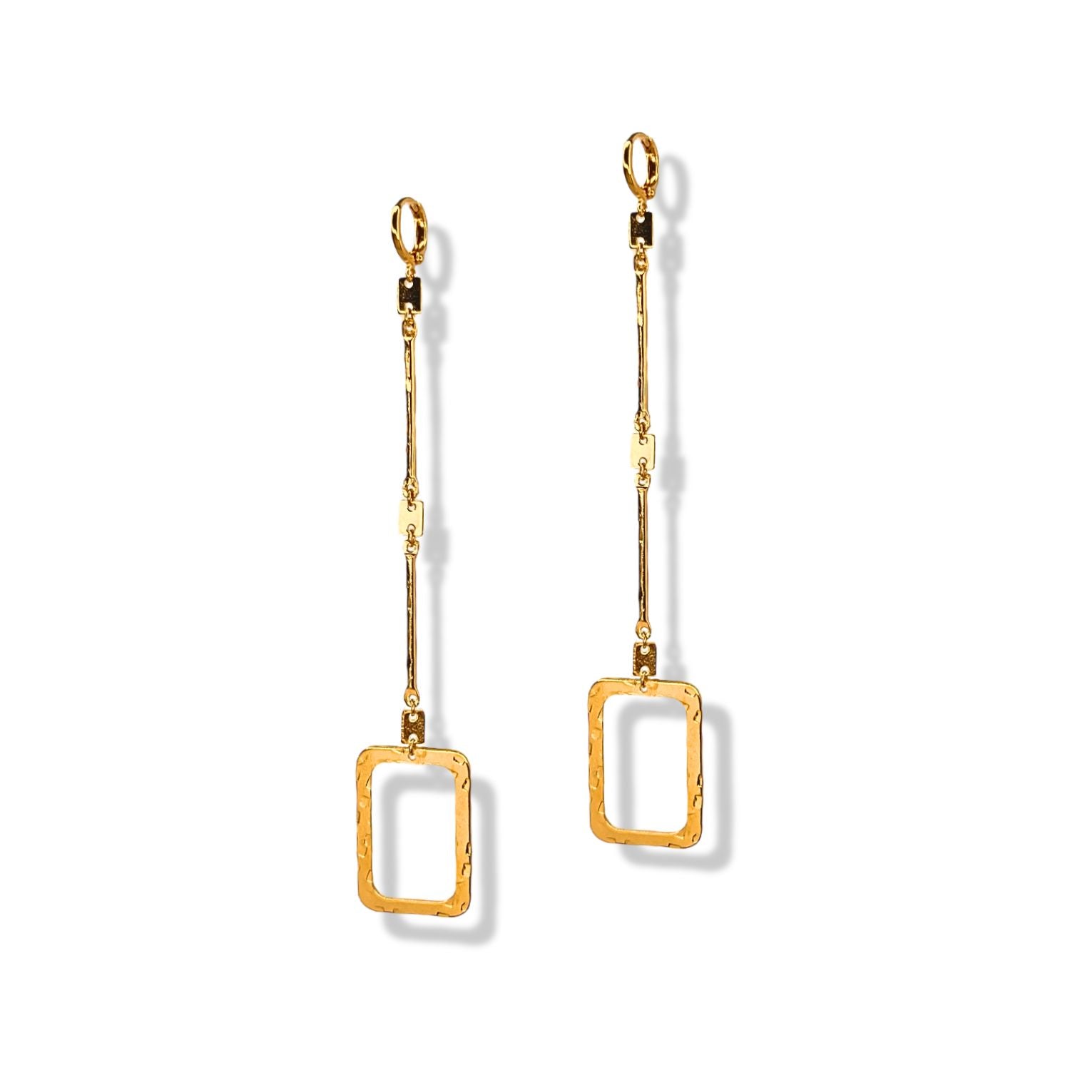 The Lattice of Gladys Drop Earrings by JAREDJAMIN Jewelry Online are long gold earrings with thin linear bars ending in open rectangular, hammered shapes. Their unique architectural design stands out on a white background with soft right shadows.