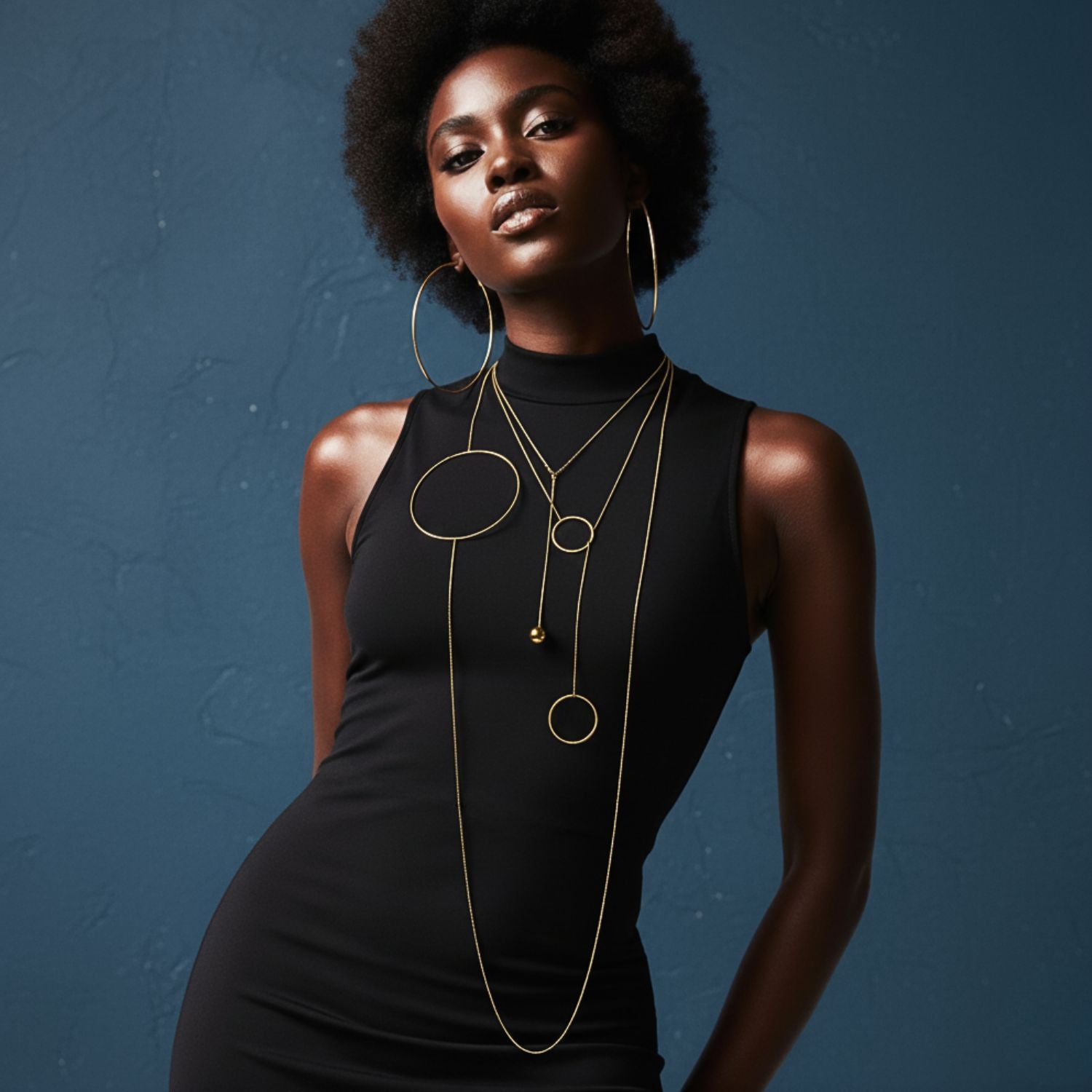 The Lindy Y-Necklace by JAREDJAMIN Jewelry Online features a minimalist 18K design with a delicate chain and two open circles, creating a modern geometric look. Tarnish resistant and shown gleaming against a plain white background.