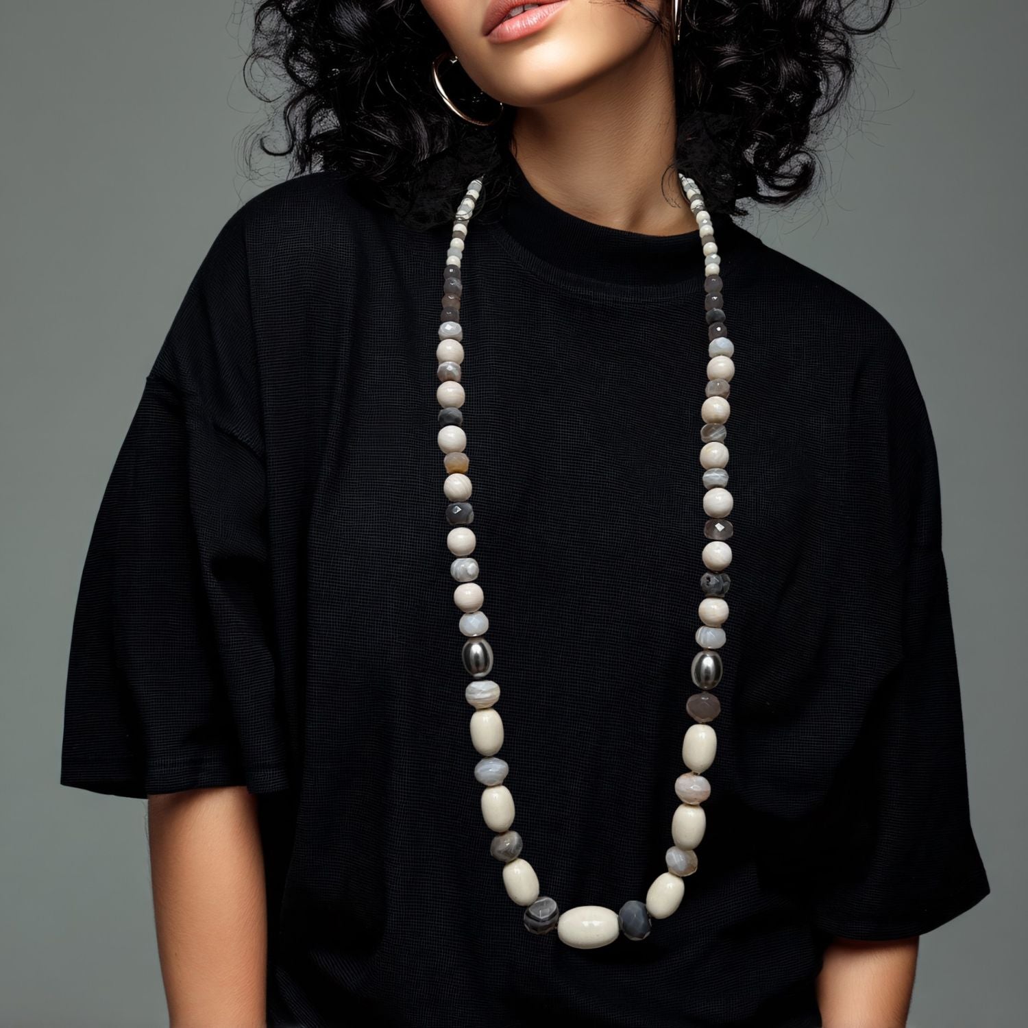 The Montana Quarry Necklace by JAREDJAMIN Jewelry Online features vintage lucite beads in alternating cream, gray, and brown round and oval shapes, arranged symmetrically with a small clasp, displayed on a white background.