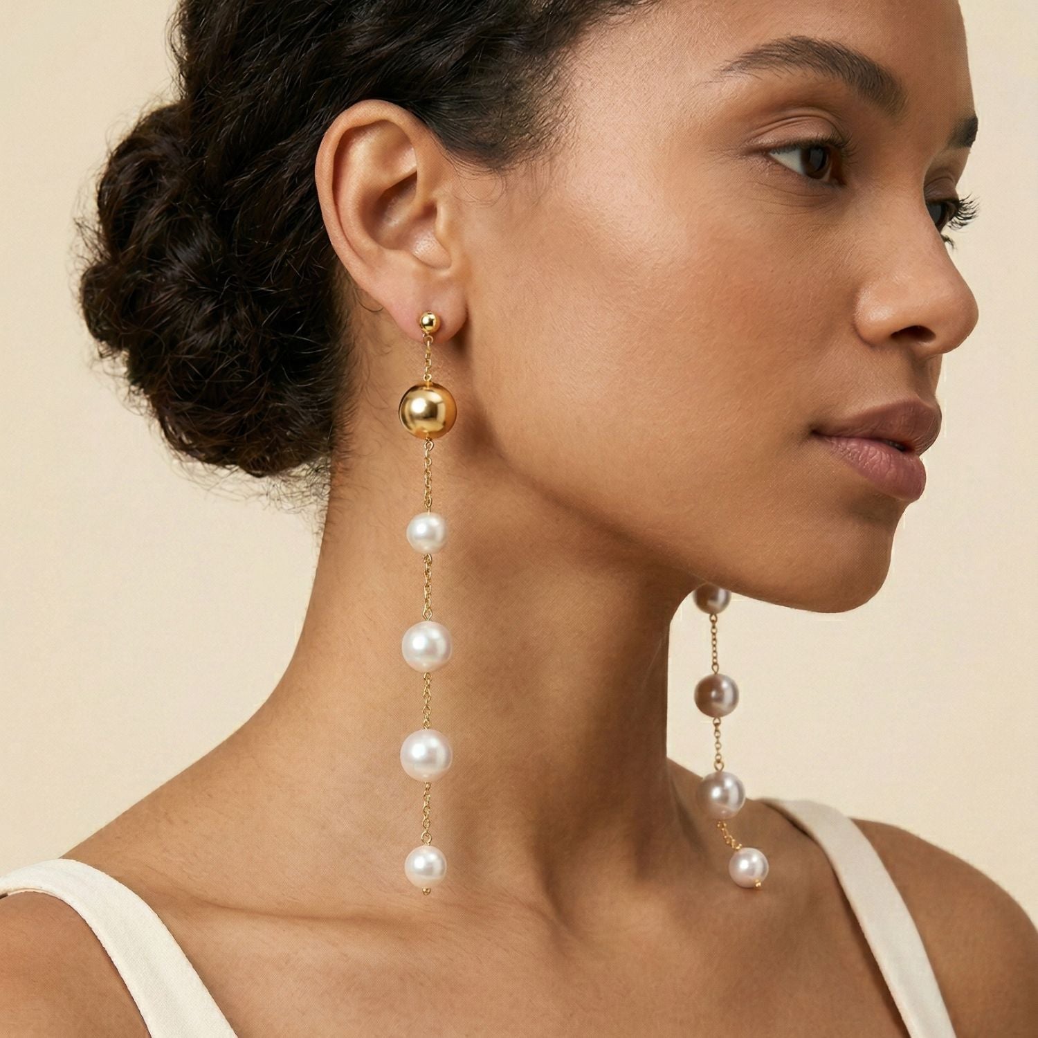 The Nora Dangle Pearl Earrings by JAREDJAMIN Jewelry Online feature a gold stud and a delicate chain with four evenly spaced white pearls on each earring, shown against a plain white background.