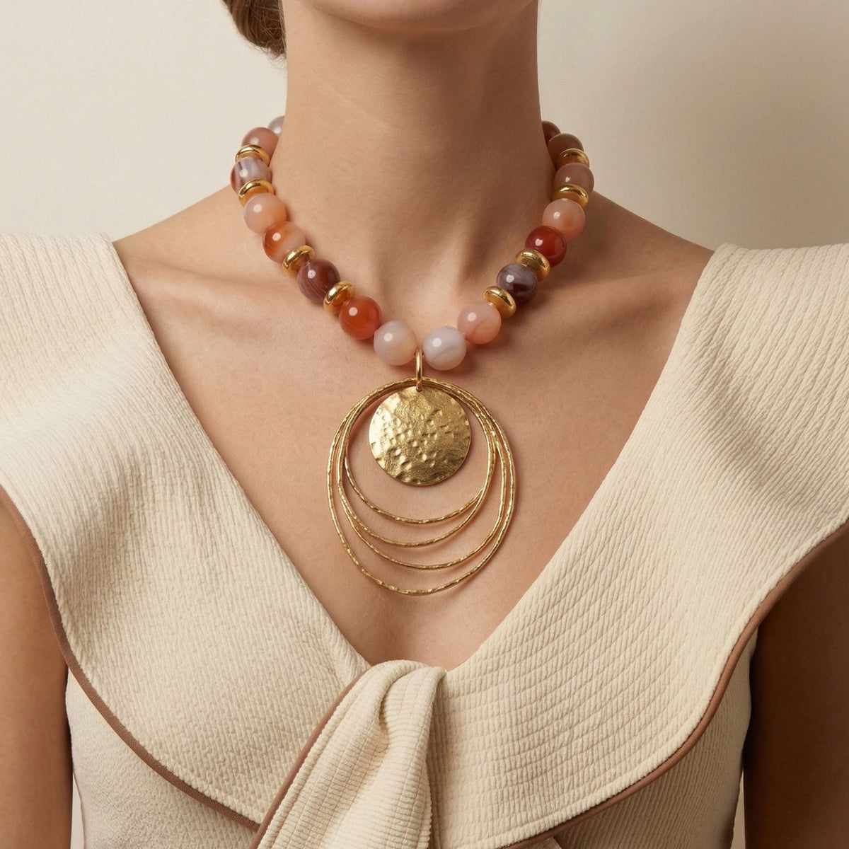 Detailed view of the Peacock Dawn Statement Pendant in Peach Agate, showcasing the signature Jared Jamin hammered gold finish and the calming, sunset-toned peach agate beads.