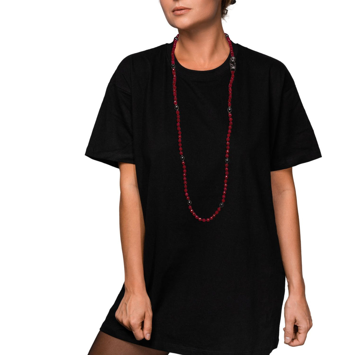Un woman in an oversized plain black T-shirt y sheer stockings stands against a fondo blanco, wearing the JAREDJAMIN Joyería Online Prying Panthers collar. Her hair is tied back, face partially out of frame, y she poses con one hand on her thigh.
