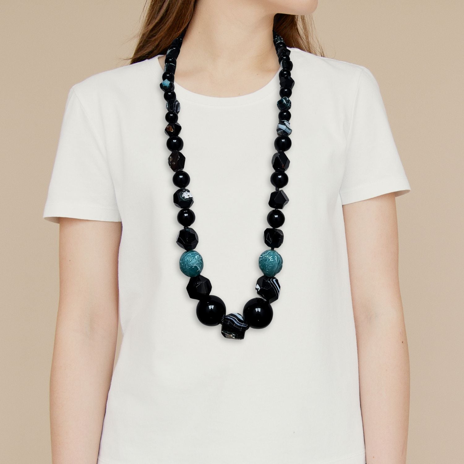 The Rock Of Gibraltar Necklace by JAREDJAMIN Jewelry Online features vintage resin beads and dyed faceted agate in black, turquoise, and metallic tones, arranged symmetrically with a silver toggle clasp, displayed oval-shaped on a white background.