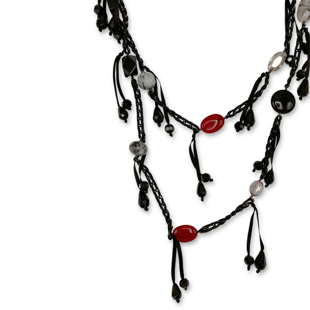 The See You Saloon Necklace by JAREDJAMIN Jewelry Online features black multi-strands with red, black, clear, and quartz beads, ribbon accents, and dangling clusters on a gunmetal-tone chain for a bold layered look.