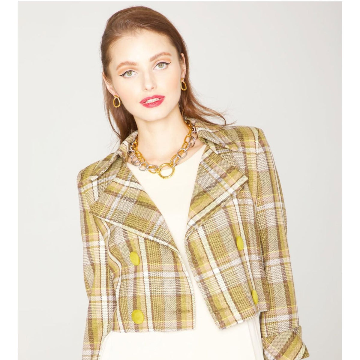 A woman with light skin and brown hair wears a yellow and beige plaid cropped blazer over a cream top. She accessorizes with 18K gold plate hoop earrings and the Silver Billie Chain Necklace by JAREDJAMIN Jewelry Online against a plain background.