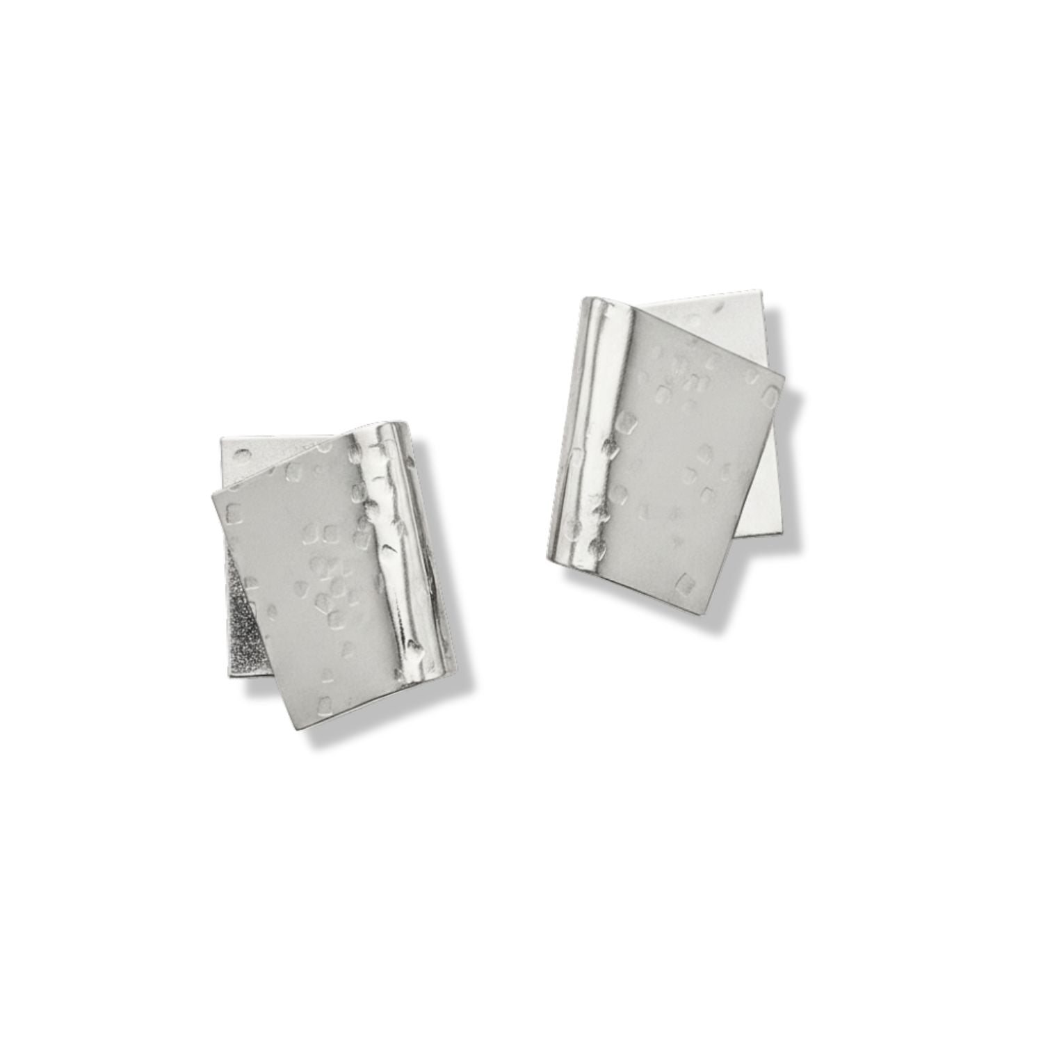 The Silver Fold Over Post Earrings by JAREDJAMIN Jewelry Online feature asymmetrical, silver-plated, layered rectangles with a textured, dotted surface, creating a modern geometric look. Shown on a white background.