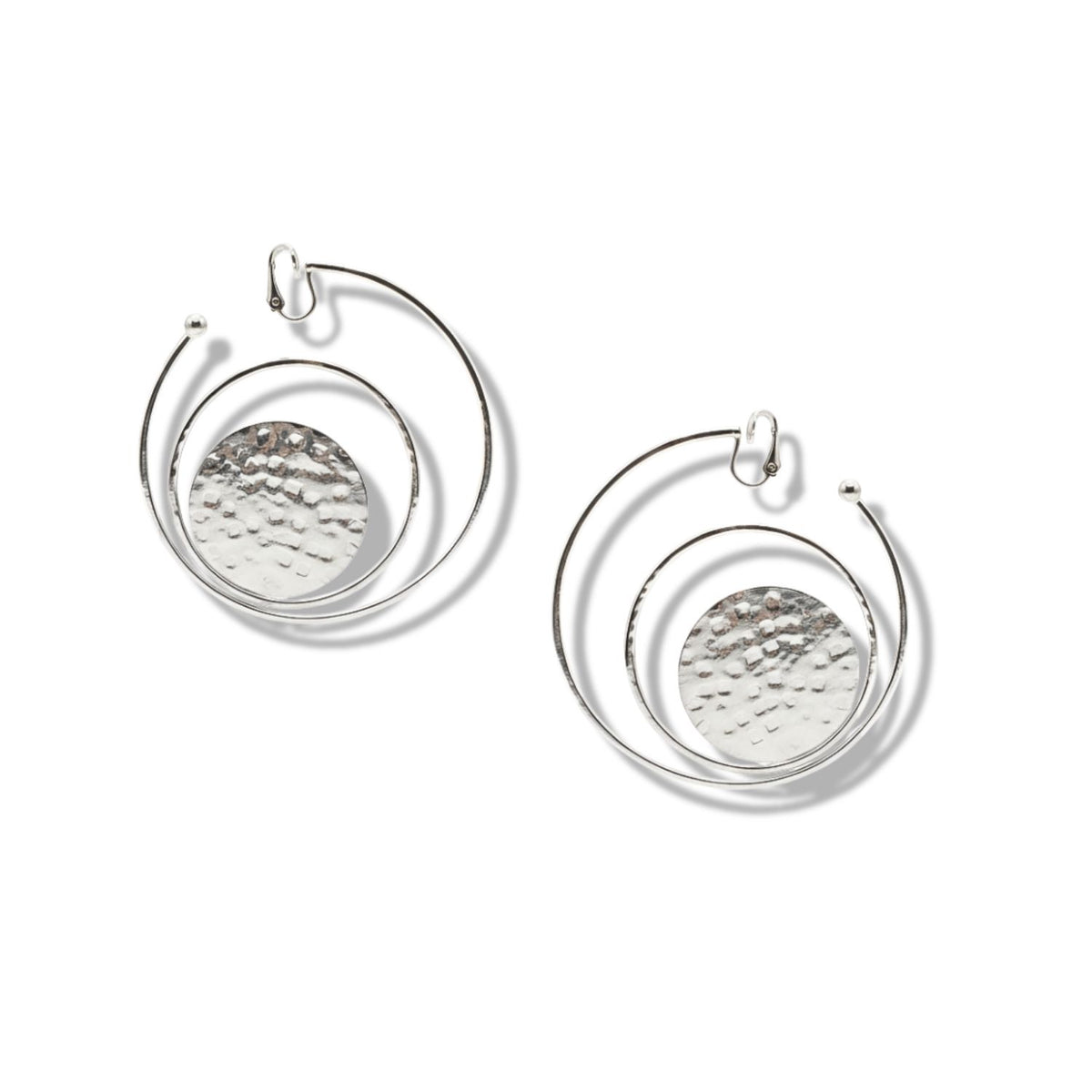 The Silver Peacock Clip On Hoop Earrings by JAREDJAMIN Jewelry Online feature large hammered discs encircled by smooth wire hoops, creating an abstract, geometric look perfect for modern style.