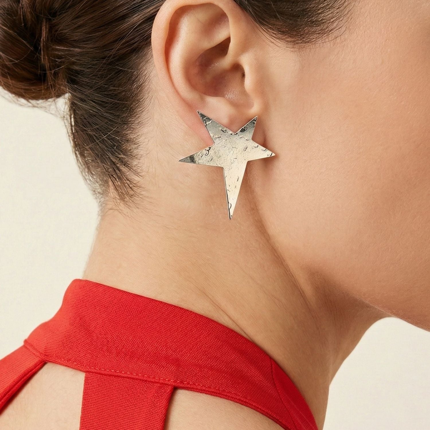 The JAREDJAMIN Jewelry Online Silver Shooting Star Clip On Earrings feature hammered, reflective five-pointed stars with sharp angles, displayed diagonally on a plain white background.