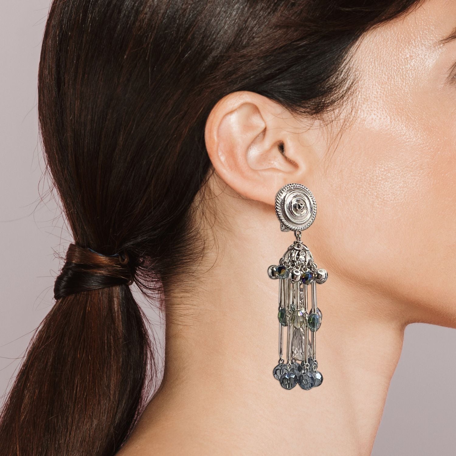 The Sixties Solar Sister Clip On Earrings by JAREDJAMIN Jewelry Online feature silver-tone chandeliers with circular studs, cascading iridescent crystals, faceted light blue beads, and silver plated components for a chic tiered look.