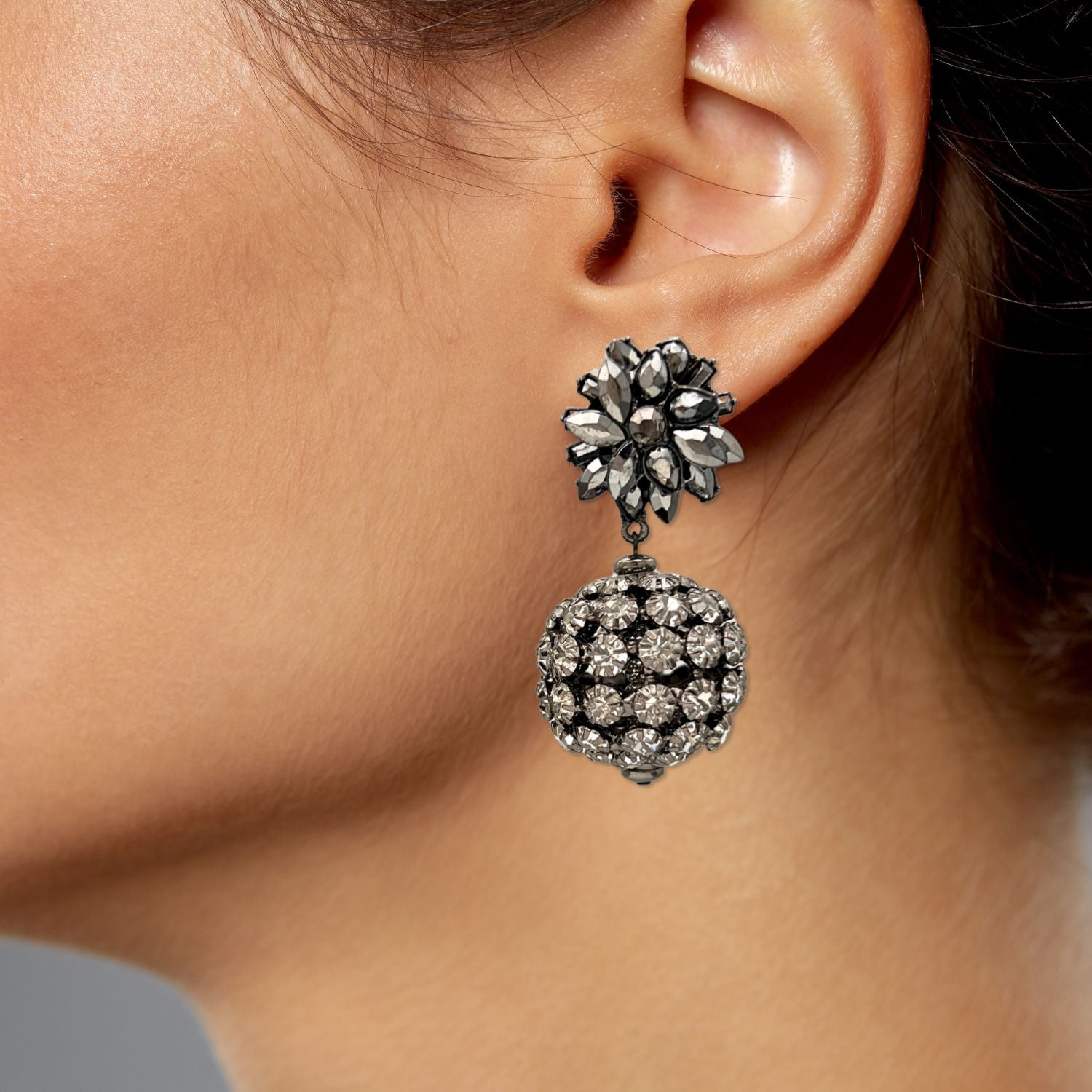 The Sparkling Bloom Earrings by JAREDJAMIN Jewelry Online feature silver-toned floral motifs, marquise stones, and a crystal-studded sphere drop in a vintage-inspired design with pewter-cast posts.